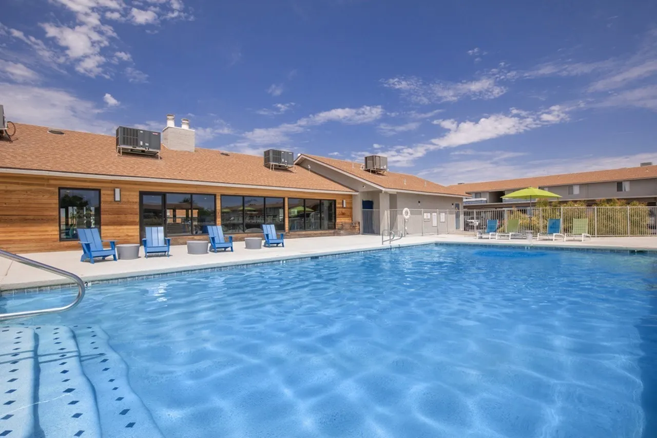 Swimming pool, lap lanes, wooden clubhouse, blue lounge chairs