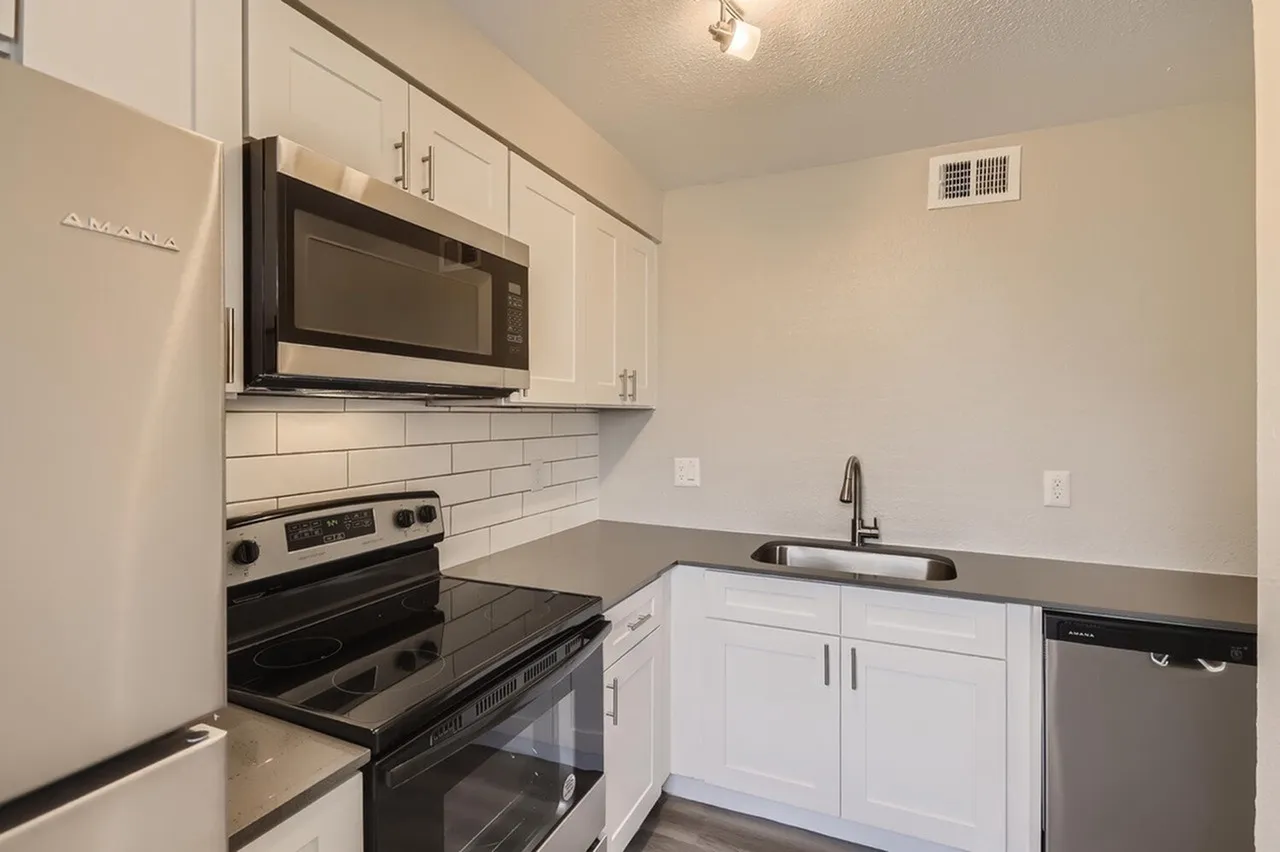Kitchen, white shaker cabinetry, gray quartz countertops, stainless appliances