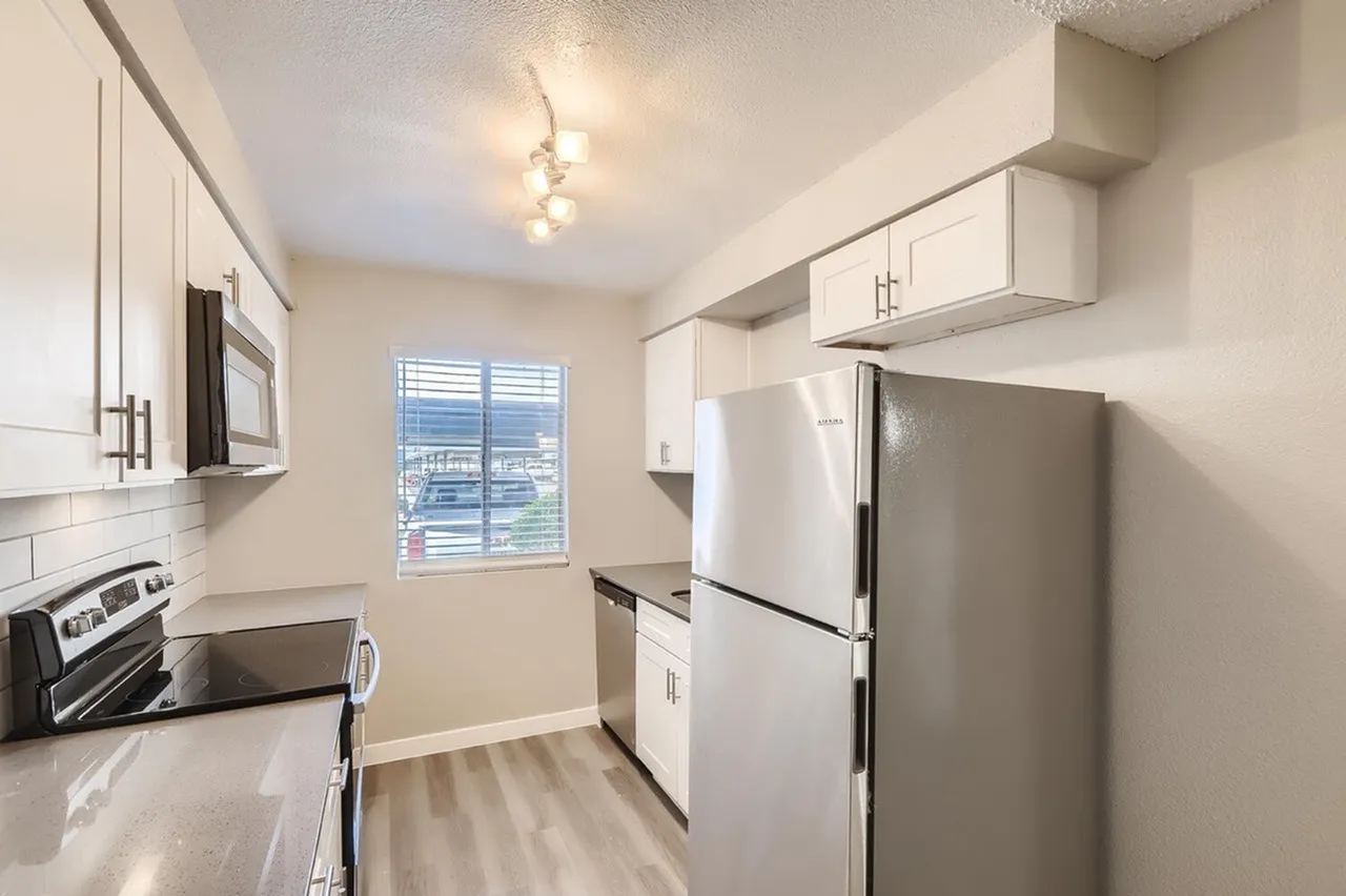 Kitchen, white shaker cabinetry, stainless steel appliances, wood-style plank flooring