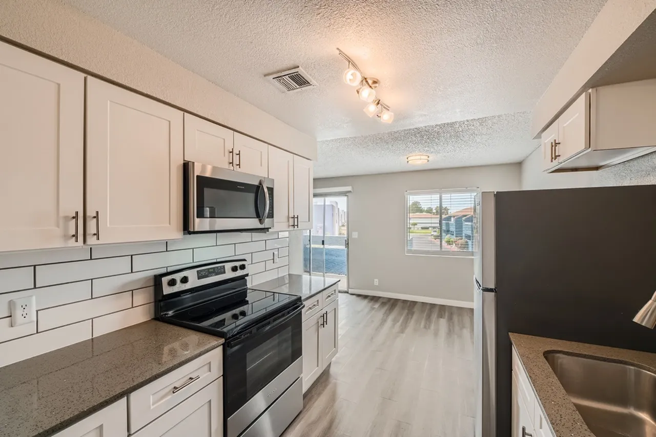 Kitchen, white shaker cabinetry, quartz countertops, stainless steel appliances, subway tile backsplash, wood-style plank flooring