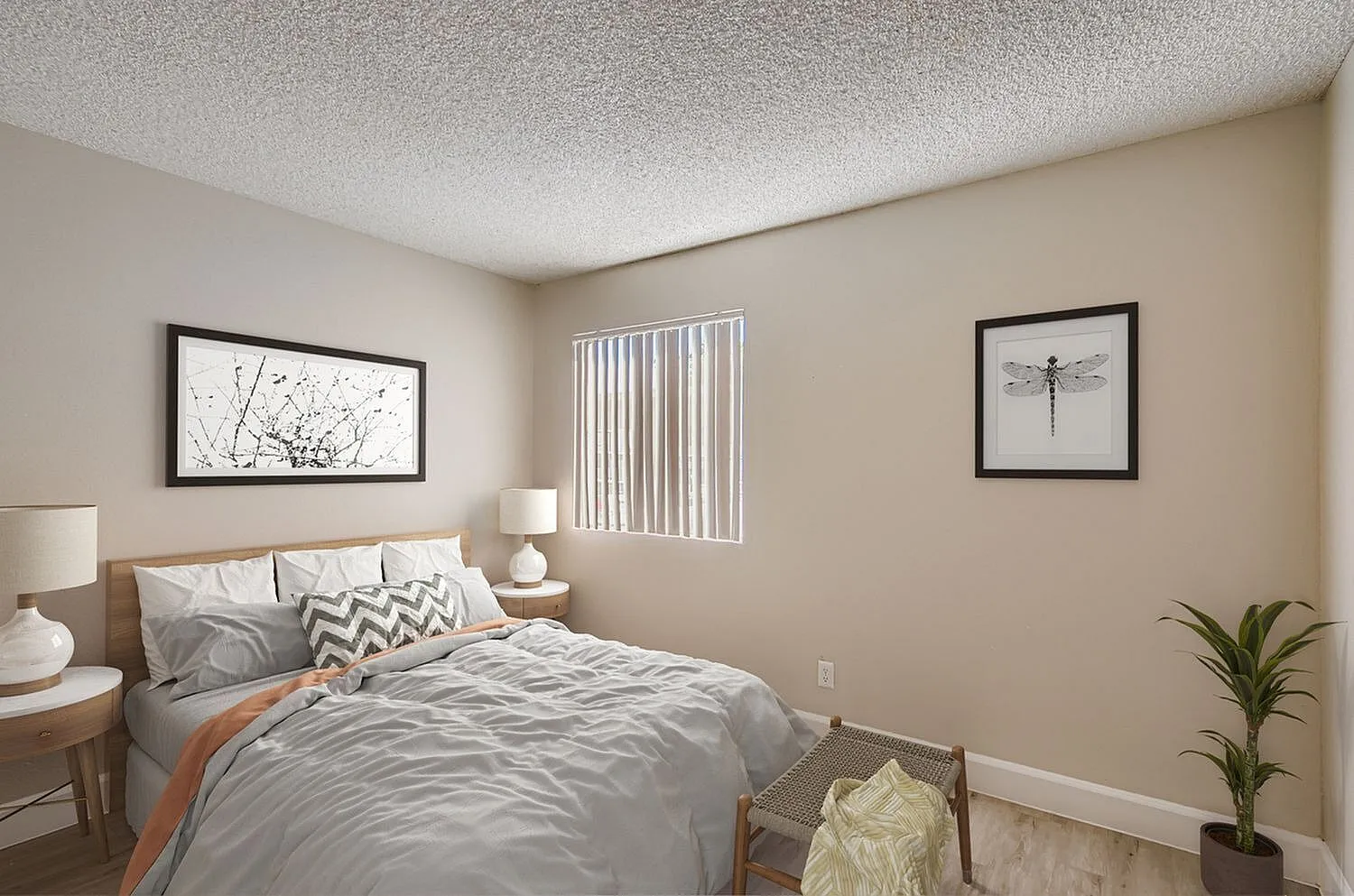 Primary bedroom, gray bedding, chevron accent pillow, wood nightstands, framed wall art