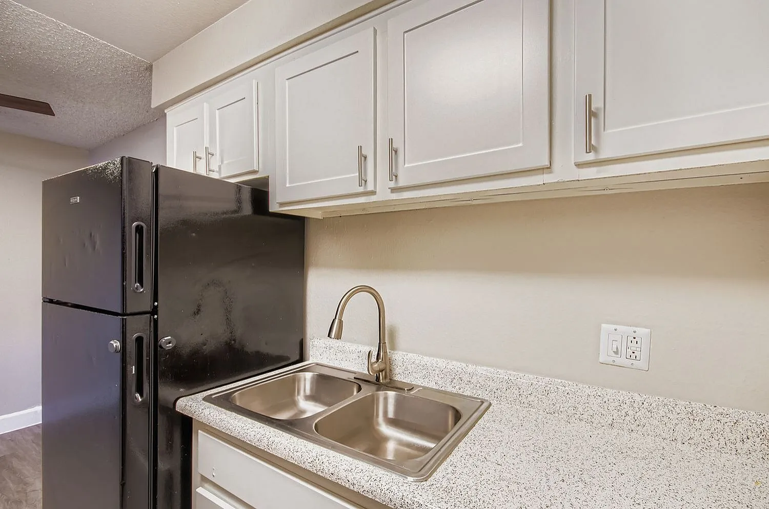 Kitchen, white shaker cabinetry, quartz countertops, stainless steel sink and faucet, black refrigerator