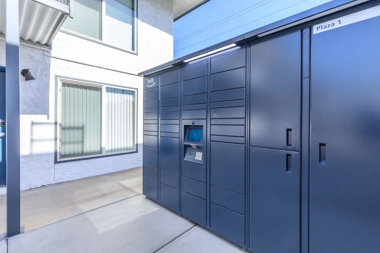 Entryway with dark gray modular package lockers, metal handles, digital access panel, polished concrete flooring