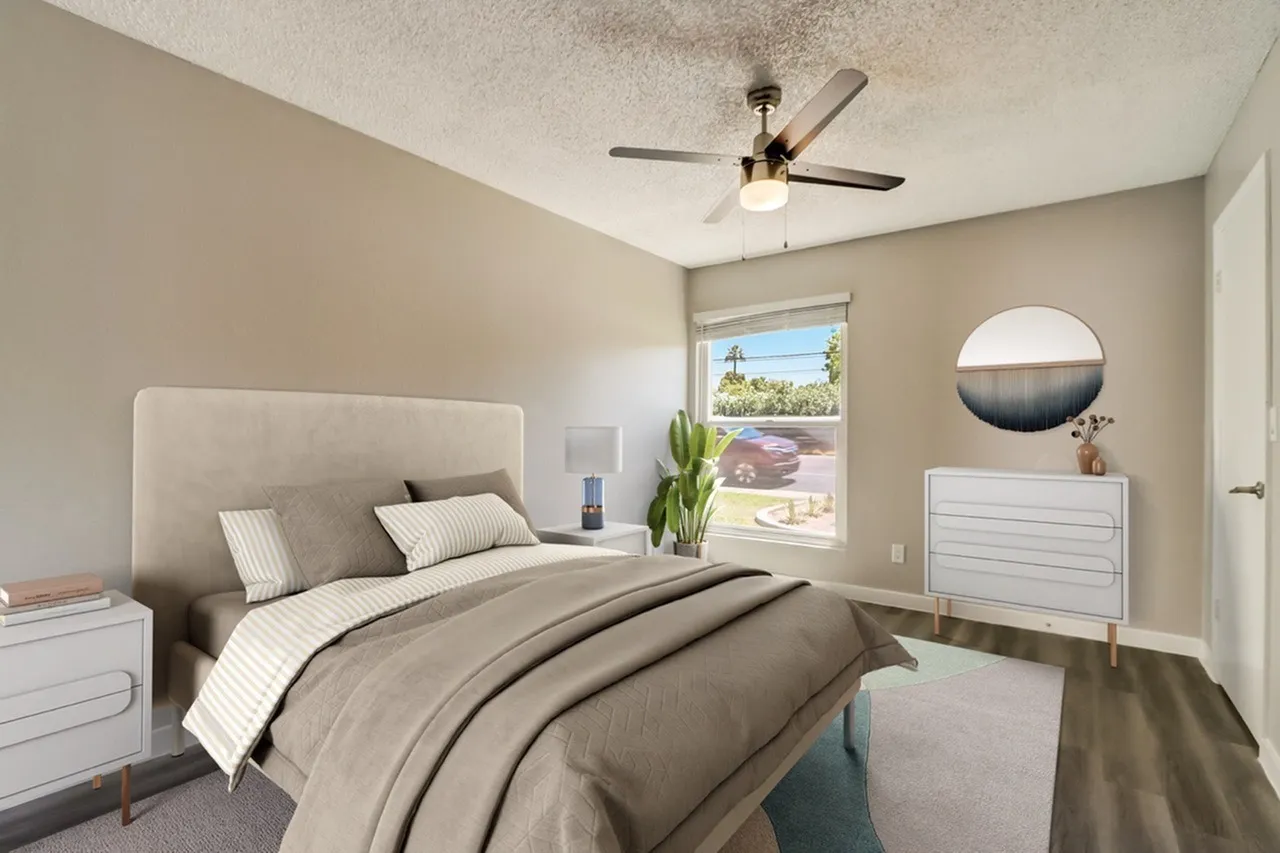 Primary bedroom, wood-style plank flooring, upholstered headboard, ceiling fan, glass sliding door