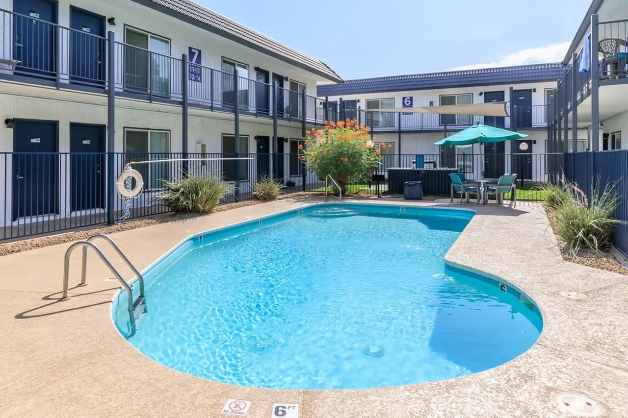 Resort-style pool, sundeck with lounge seating, multi-story residential building, Phoenix