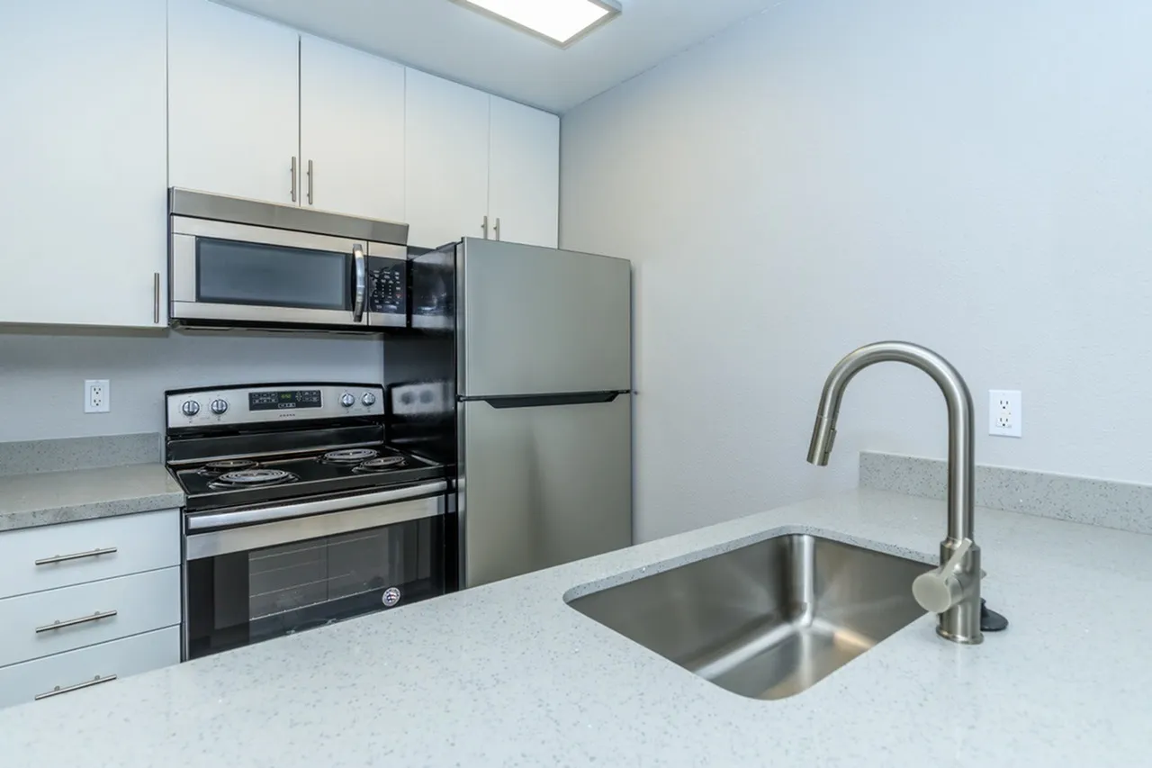 Kitchen, white shaker cabinetry, quartz countertops, stainless steel appliances, stainless sink