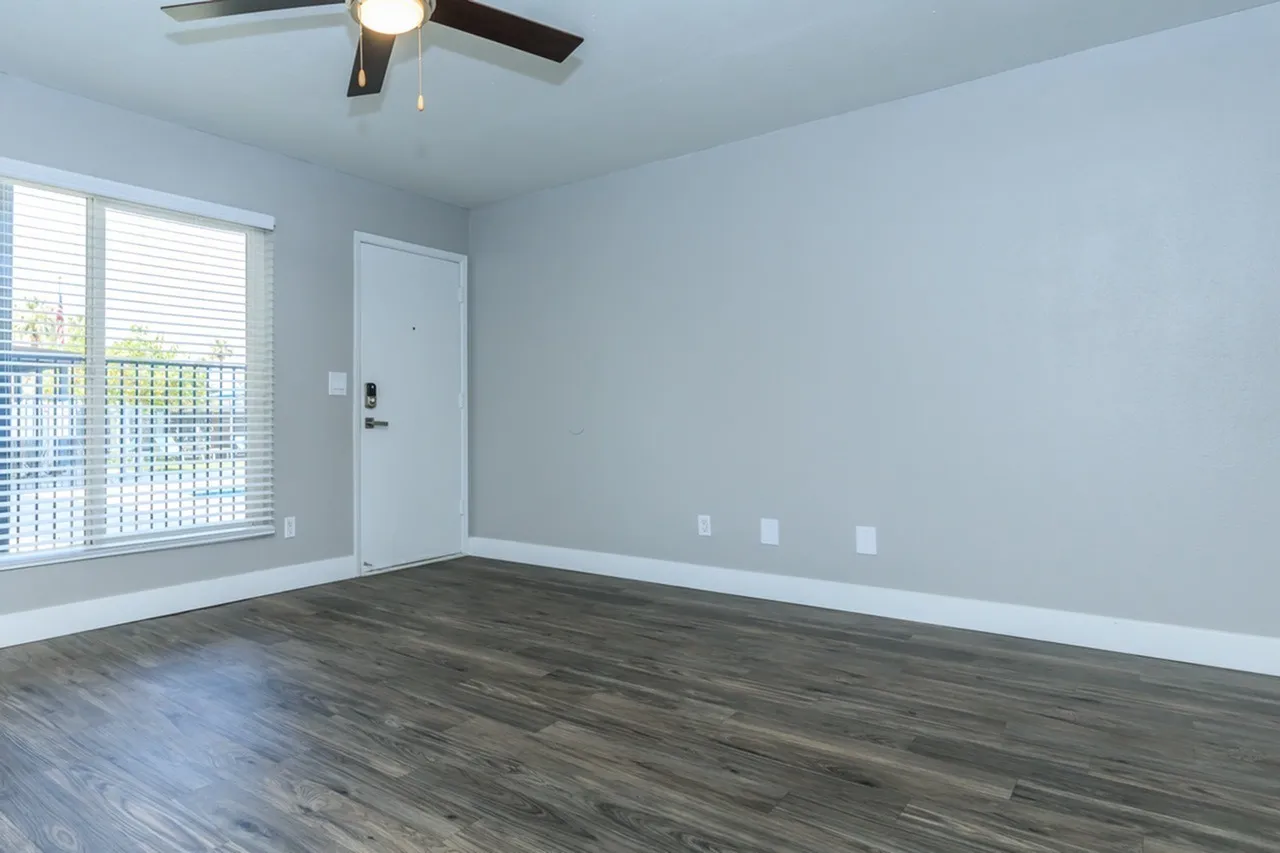 Primary bedroom, wood-style plank flooring, ceiling fan with light, balcony door