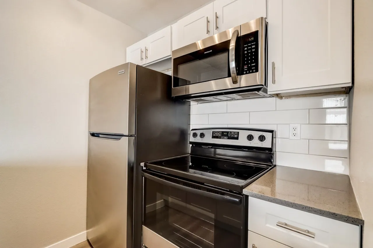 Kitchen, white shaker cabinetry, stainless steel appliances, gray countertops, subway tile backsplash