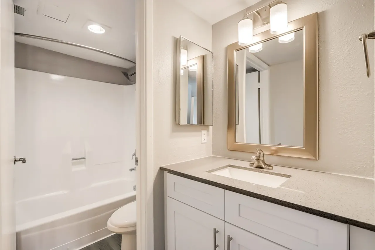 Bathroom, white cabinetry, quartz countertop, framed mirror, chrome fixtures