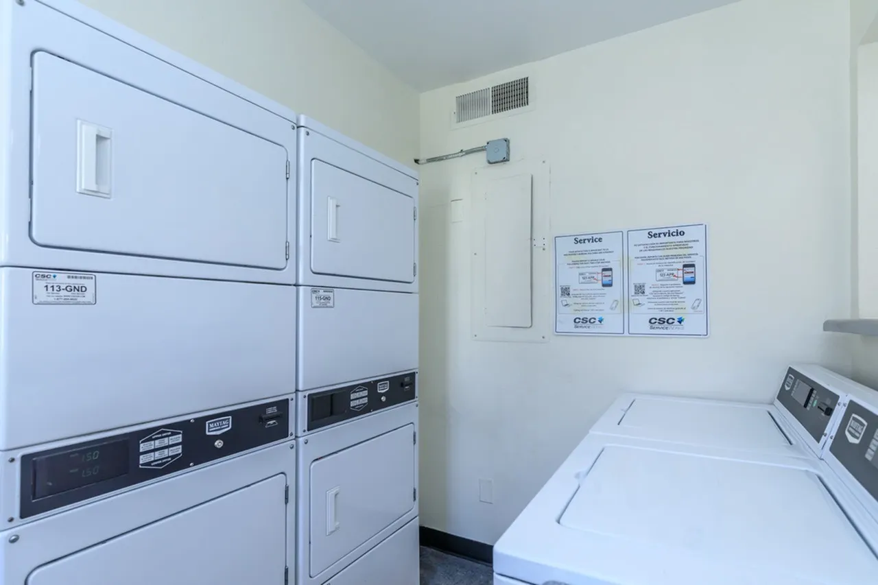 Laundry room, stackable dryers, white appliances, service signs