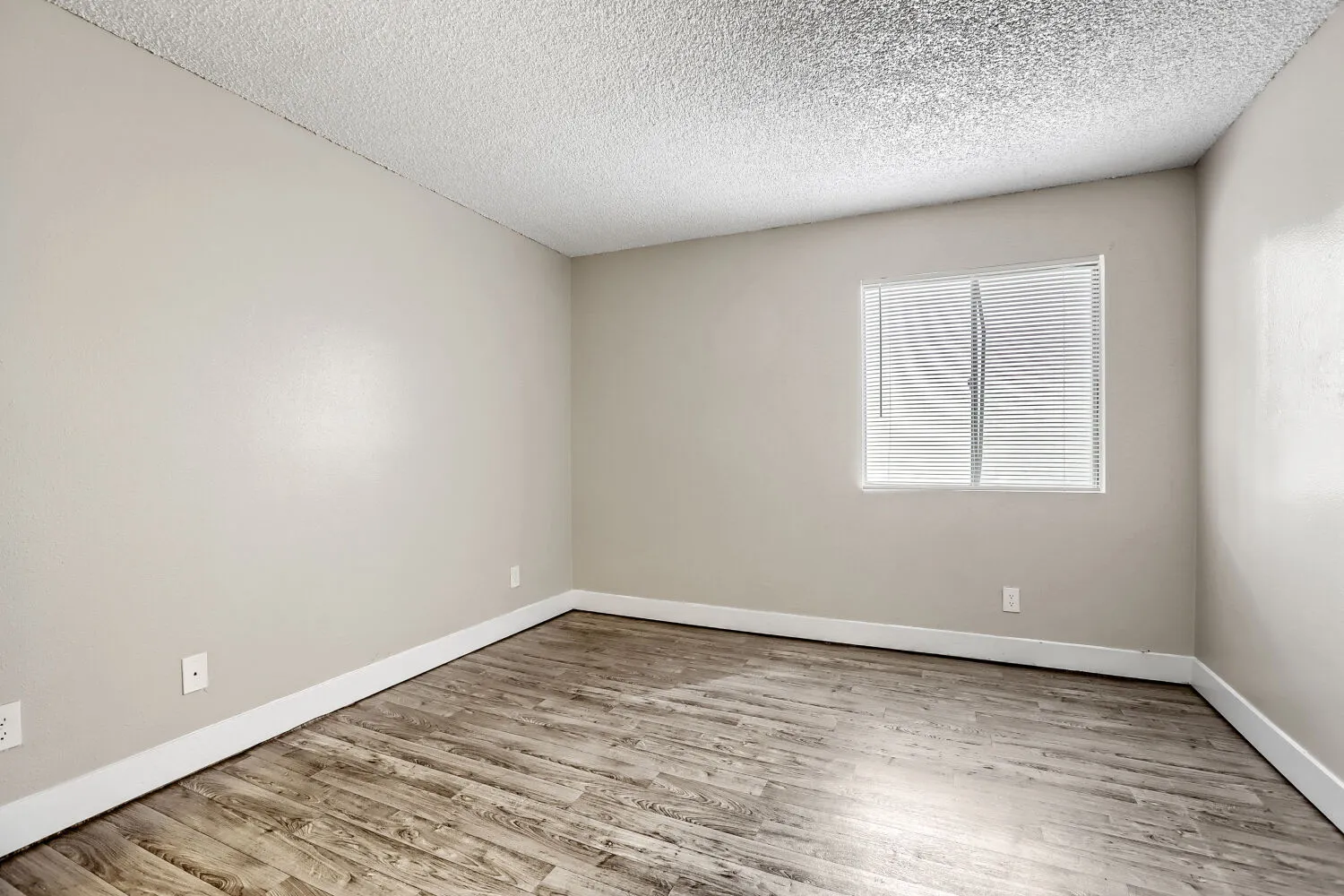 Bedroom with wood-style plank flooring and window