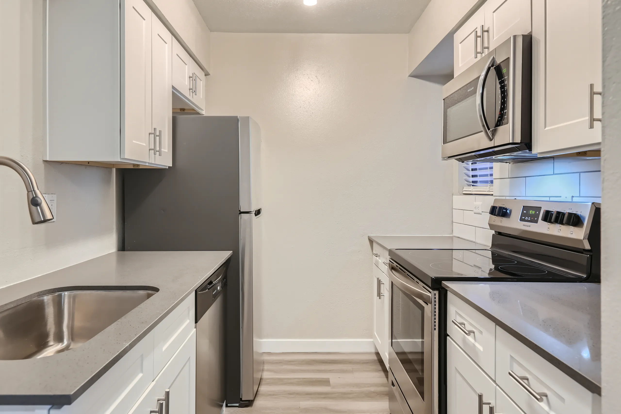 Kitchen with white cabinetry, stainless steel appliances, and tile backsplash
