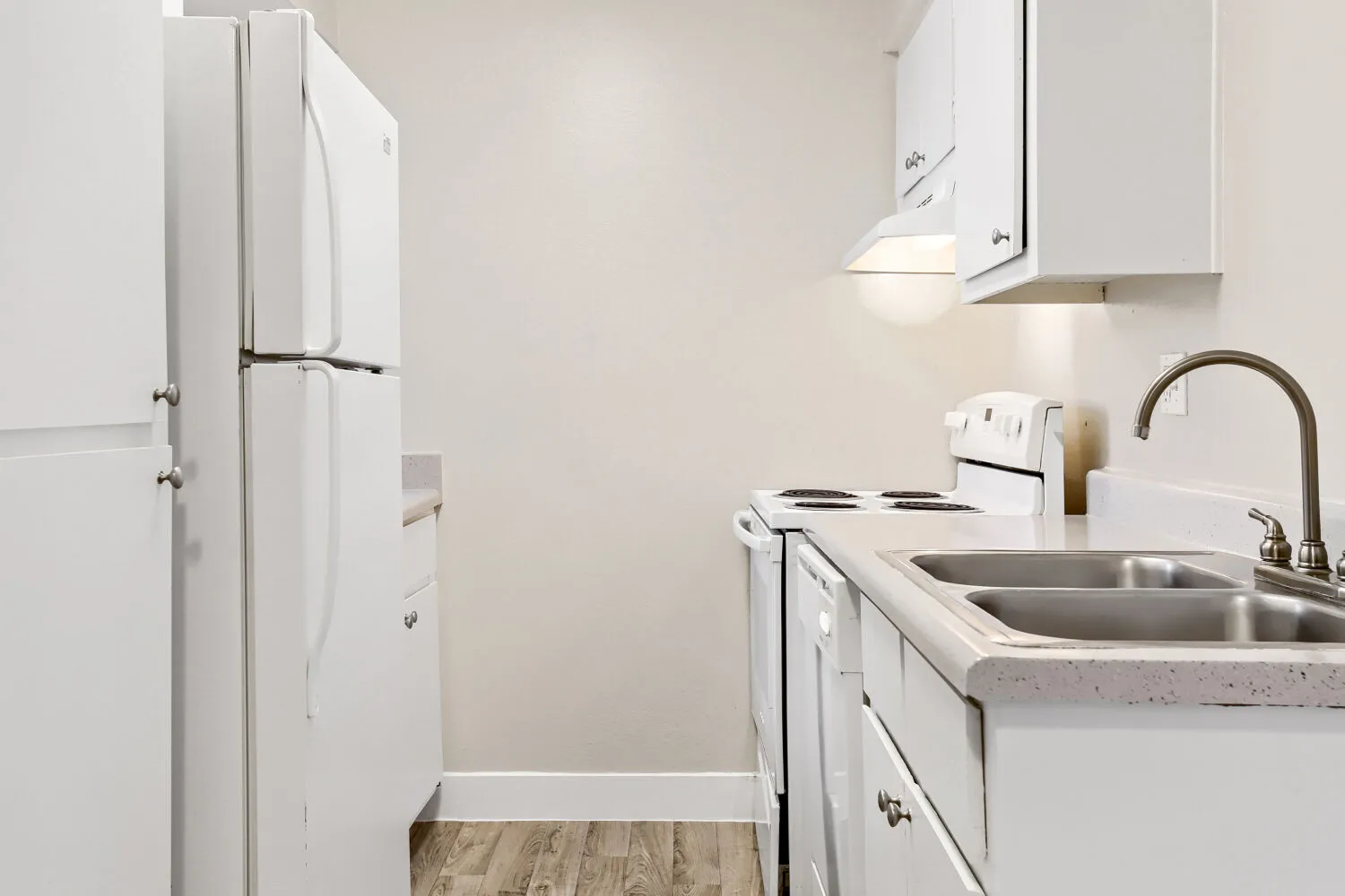Kitchen with white cabinetry, electric range, and double-basin sink