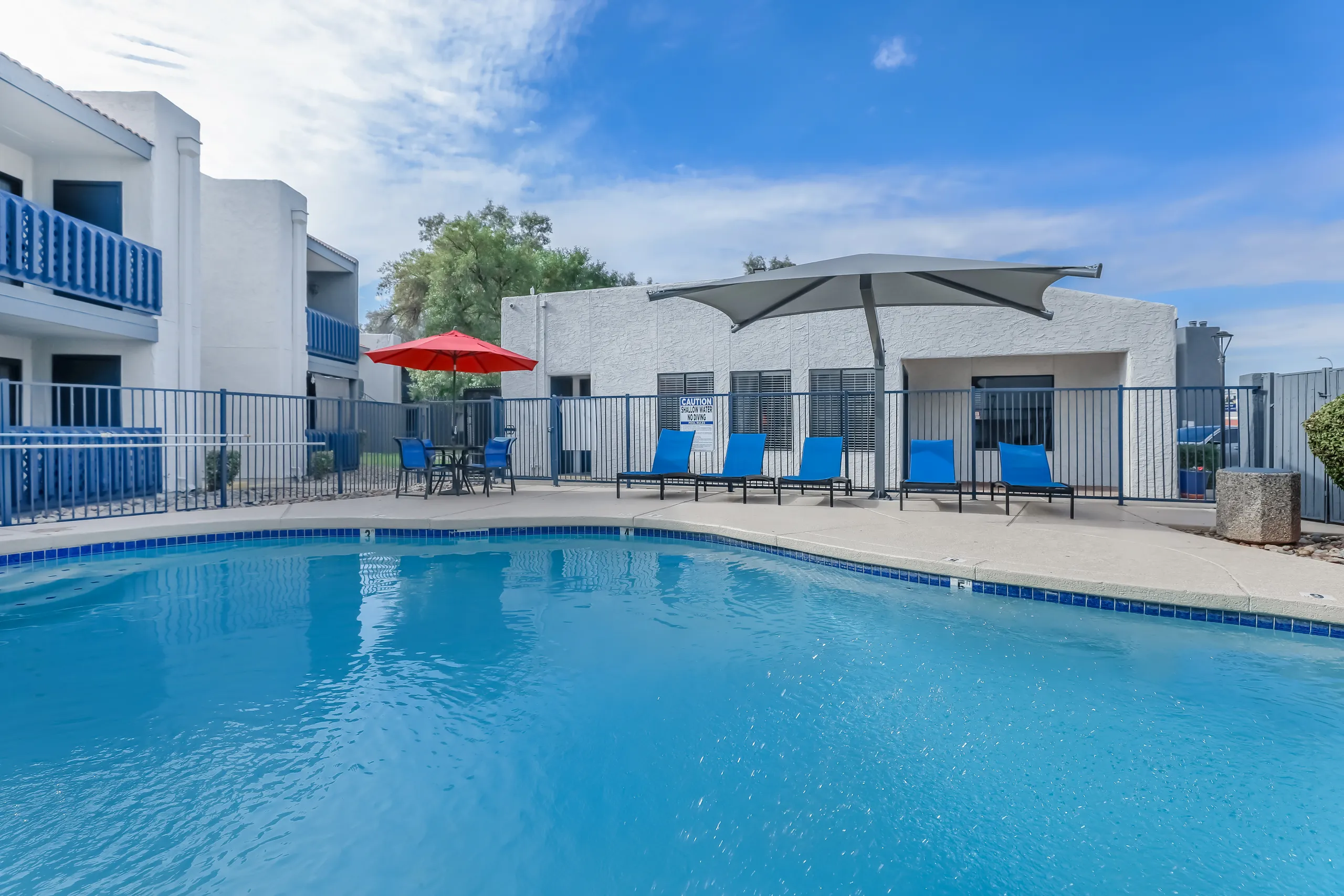Resort-style pool with lounge chairs and patio umbrella