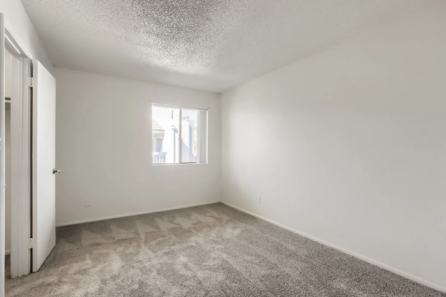 Bedroom with carpet flooring and view into walk-in closet