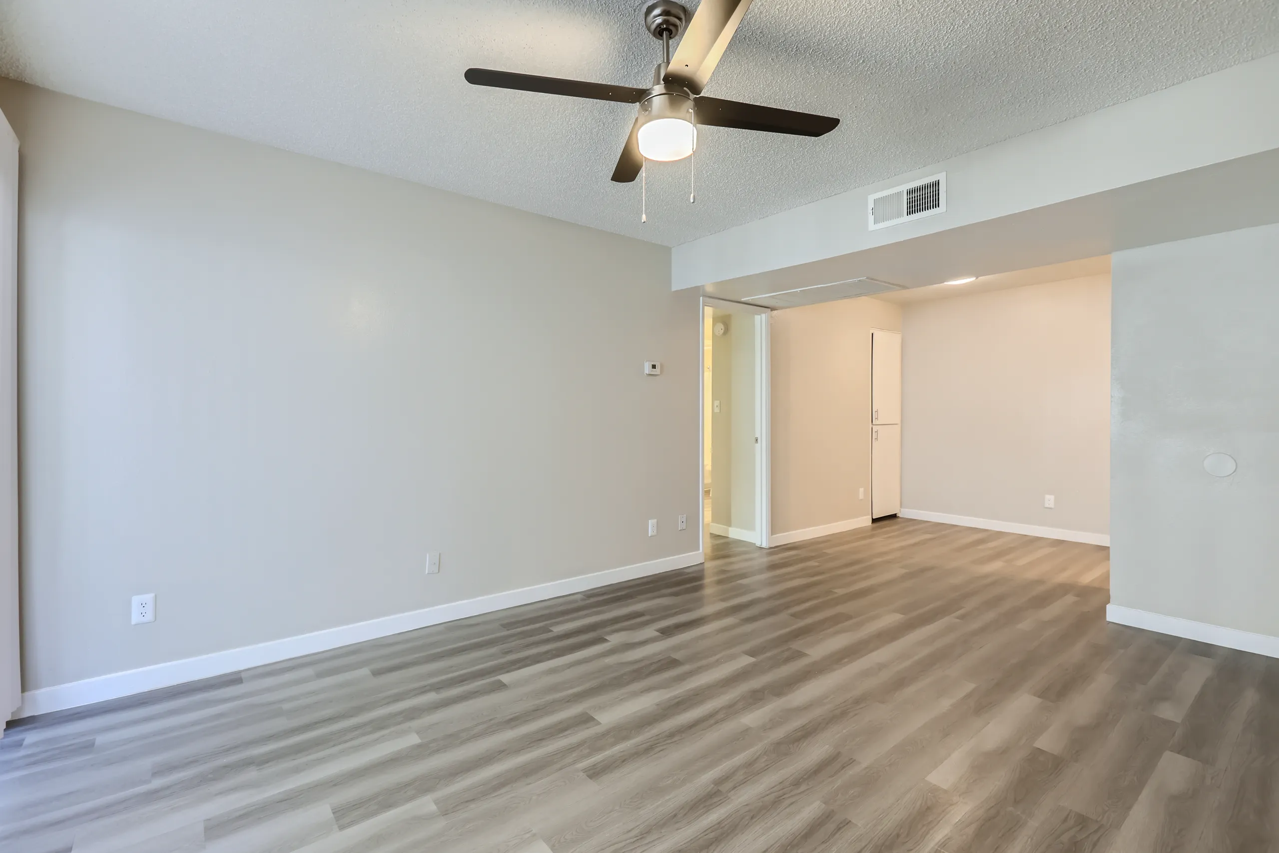 Living room with view into kitchen and hallway