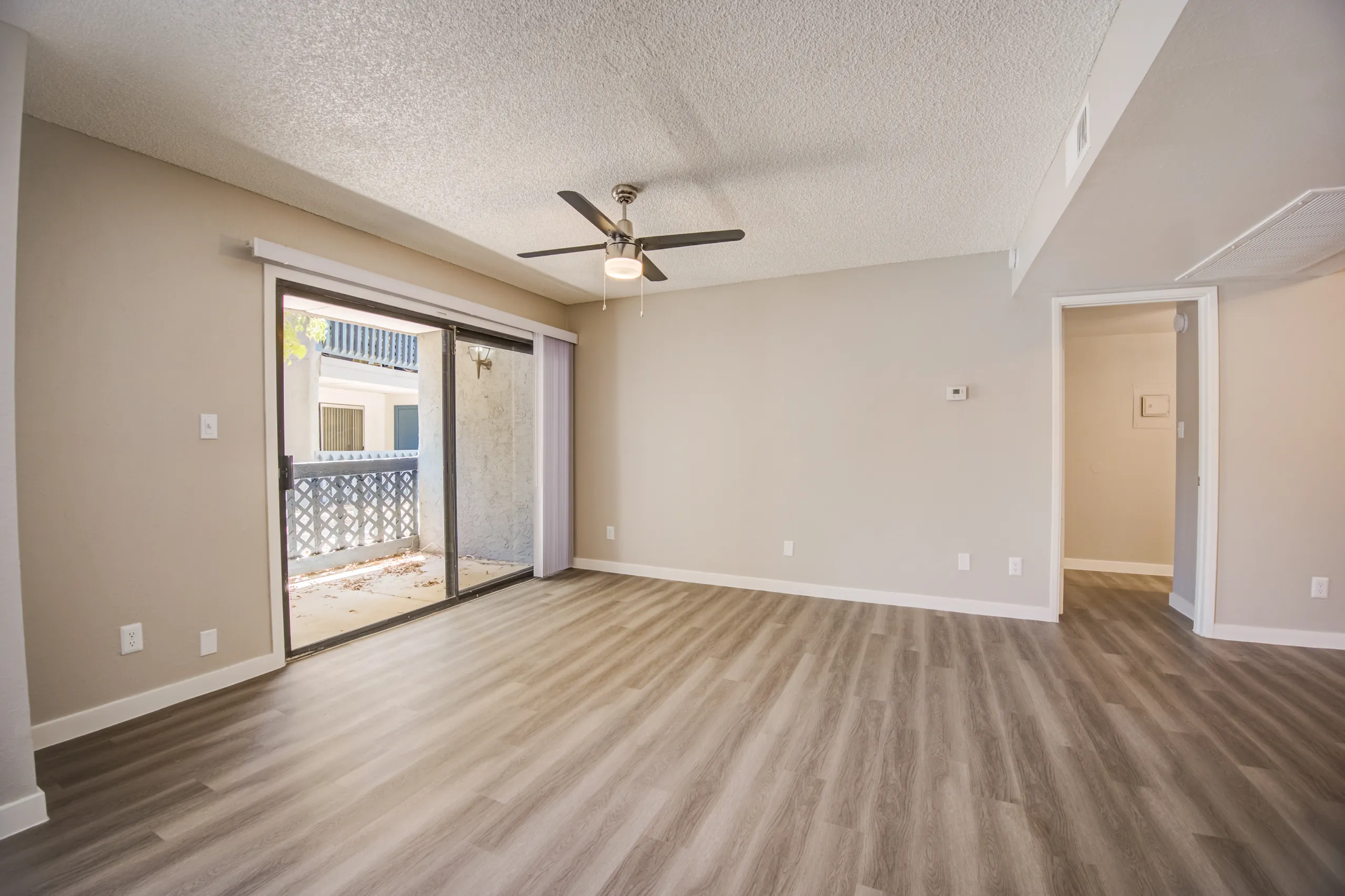 Living room with ceiling fan and sliding glass door to patio