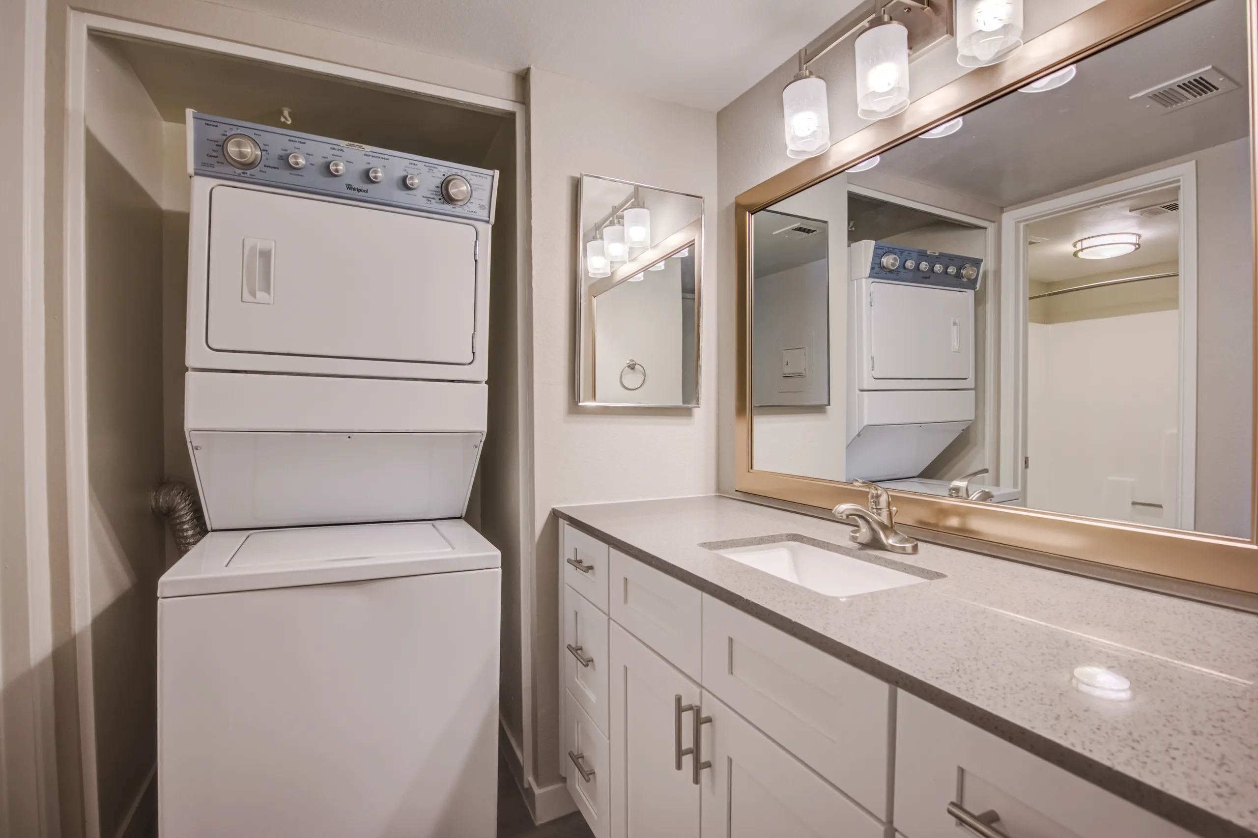 Primary bathroom vanity with in-unit stacked washer and dryer