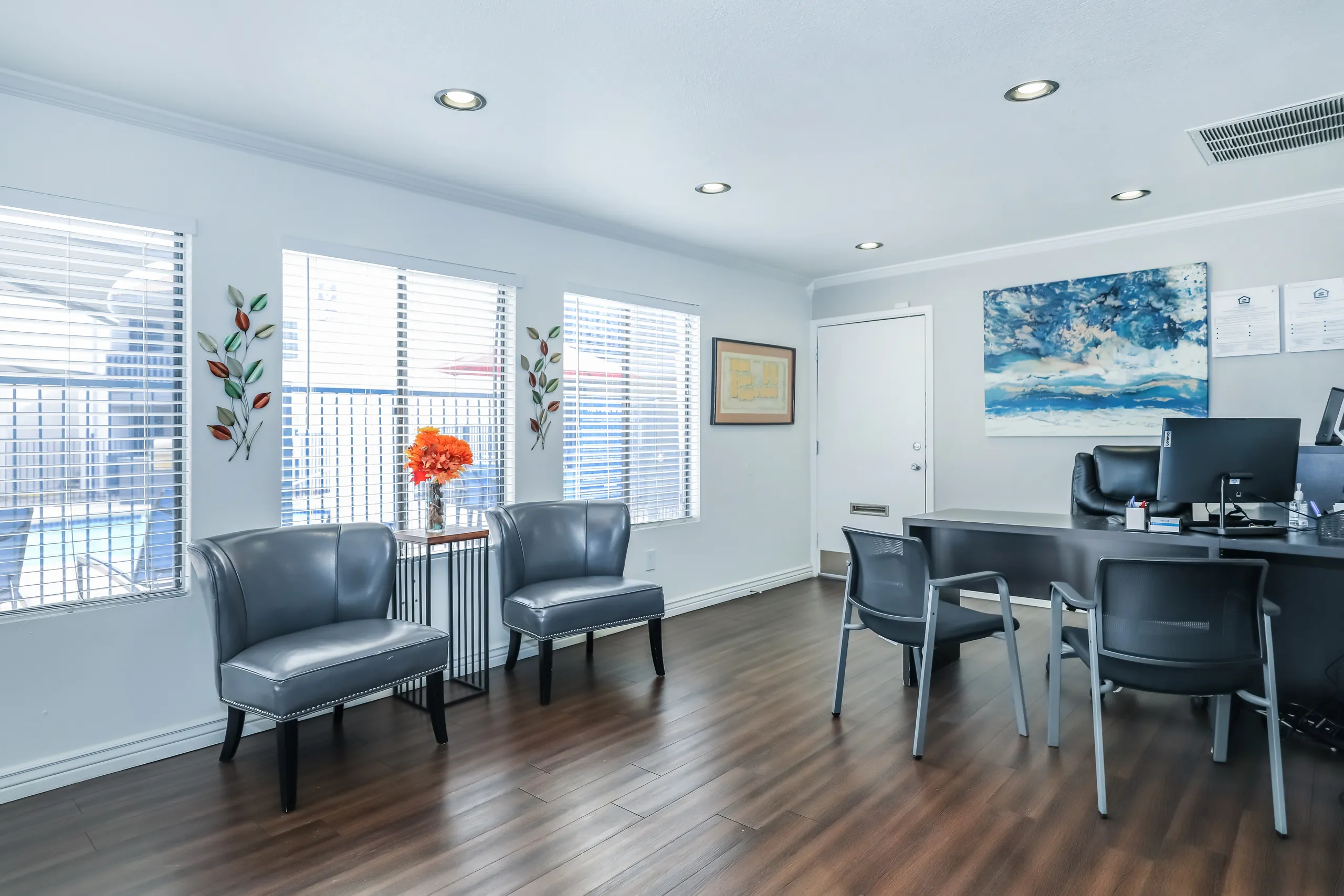 Leasing office interior with guest seating and staff workstation