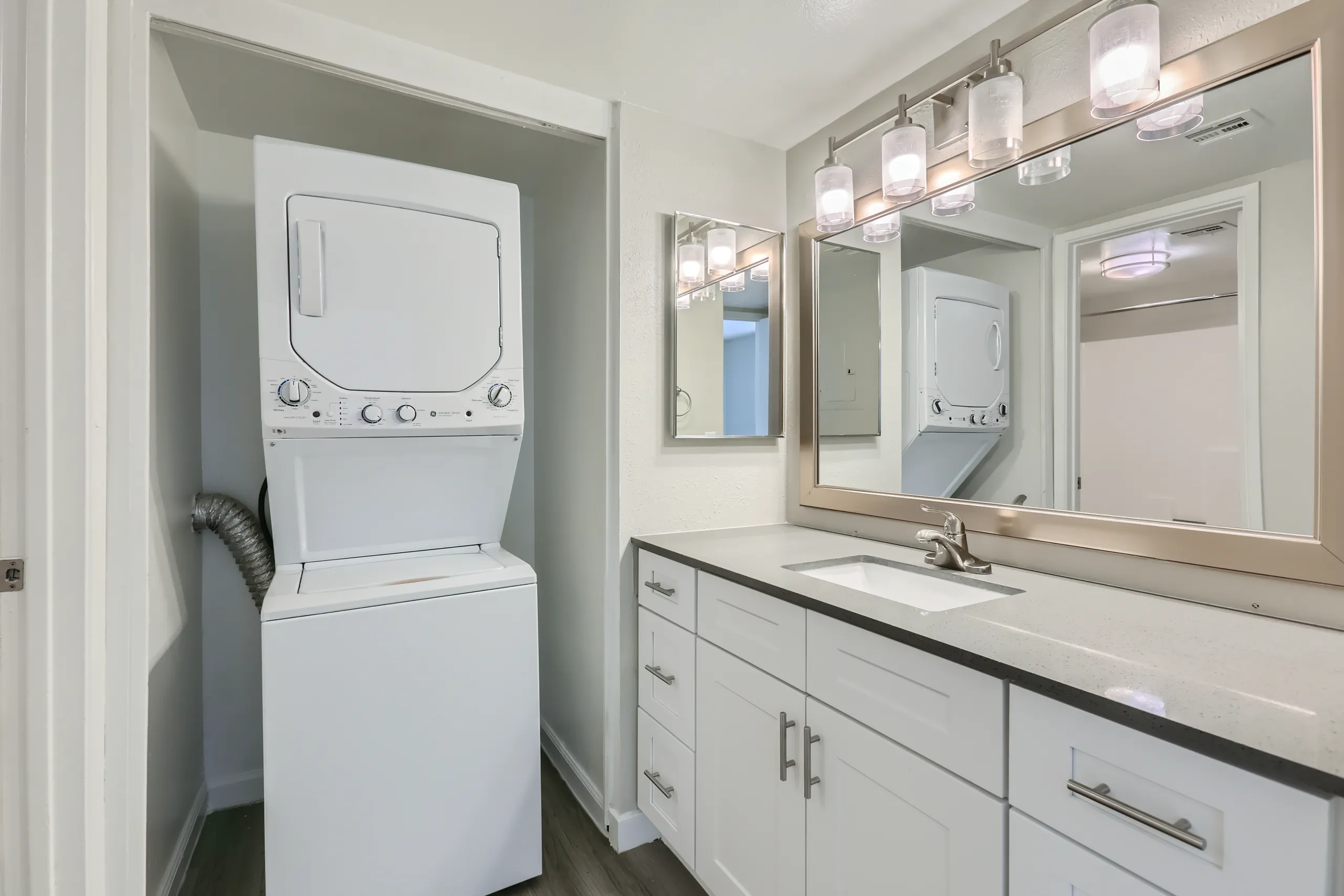 Primary bathroom vanity with in-unit stacked washer and dryer