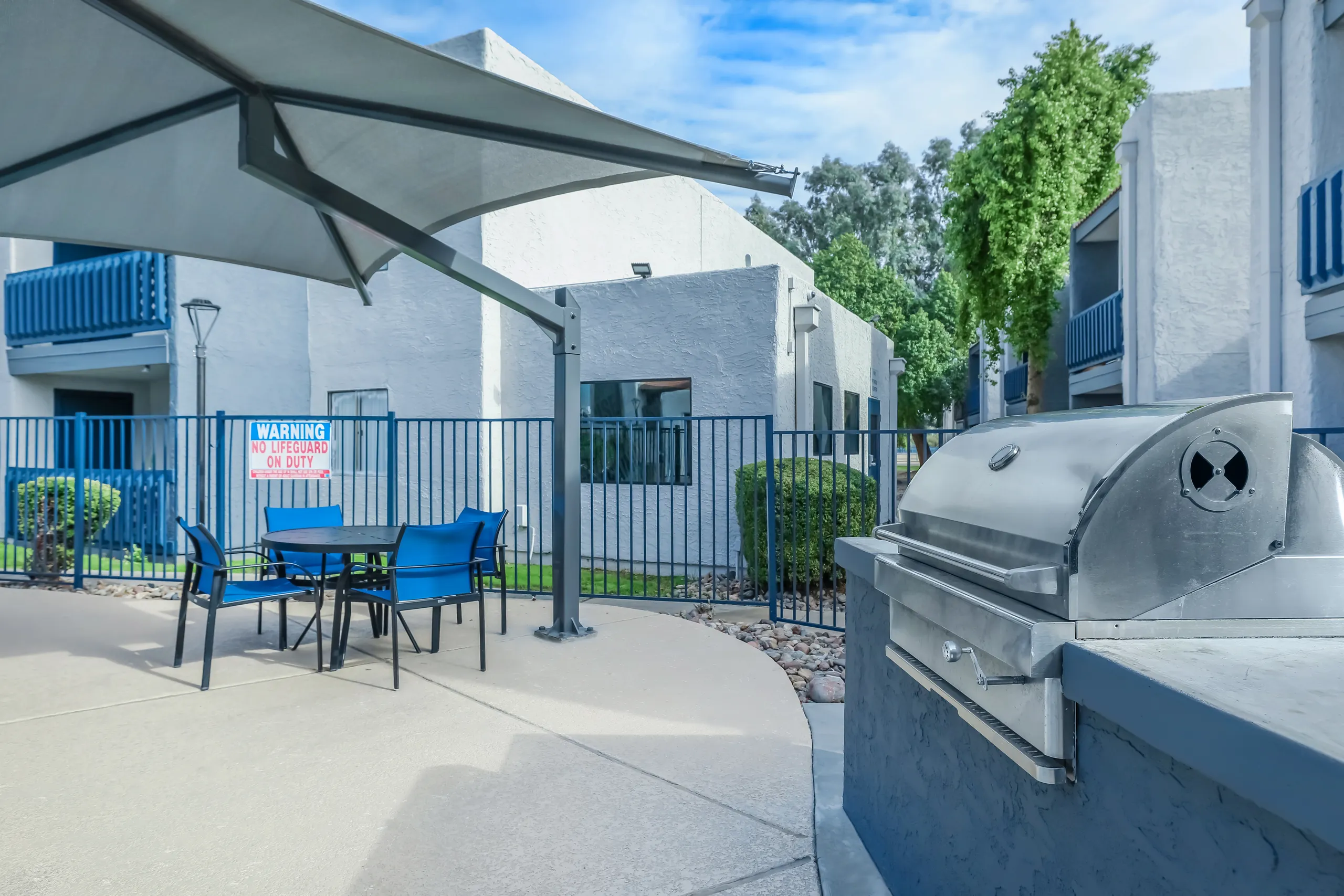 Outdoor grilling station and covered patio seating near the pool