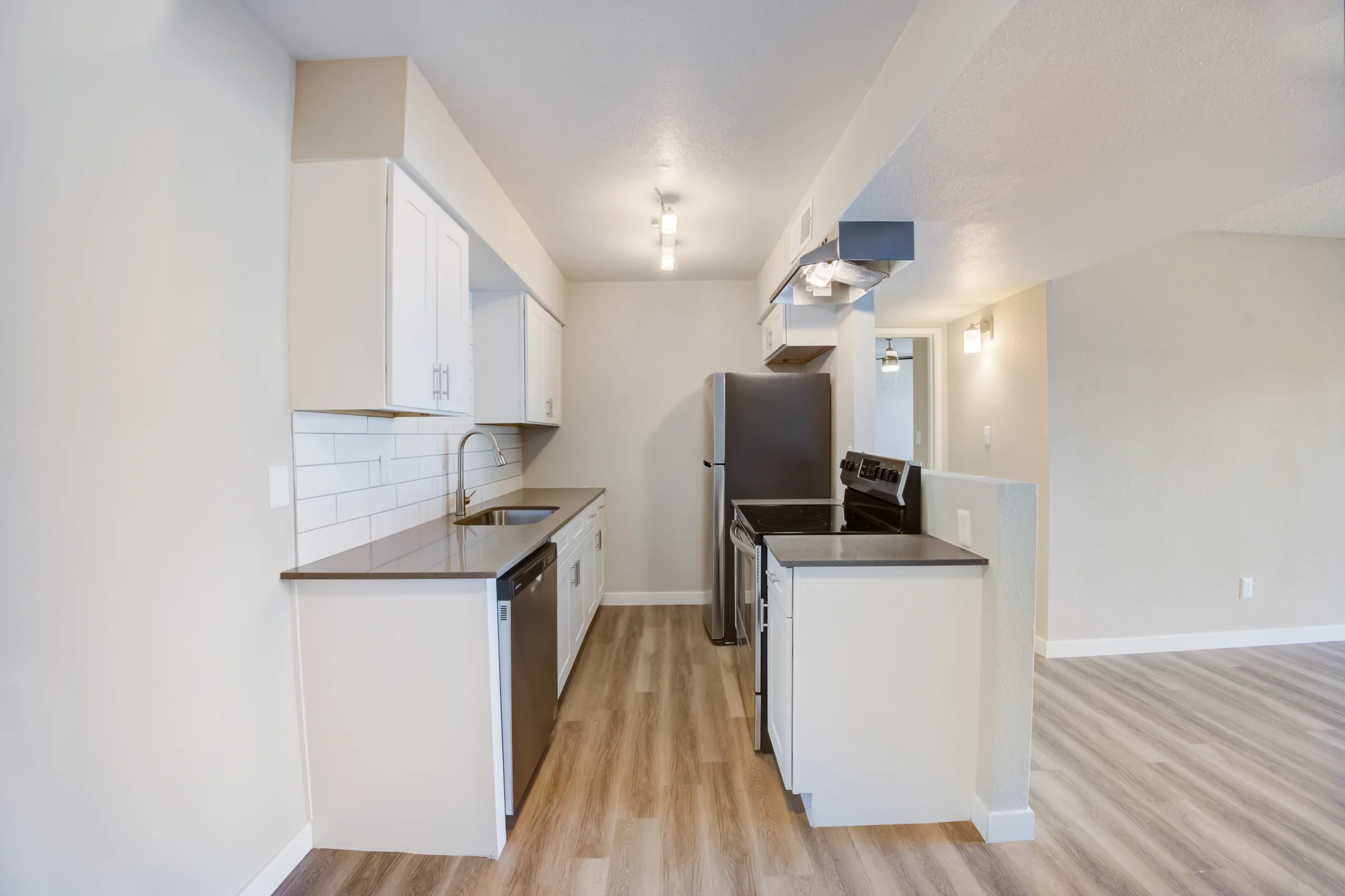 Kitchen with white cabinetry, stainless steel appliances, and subway tile backsplash