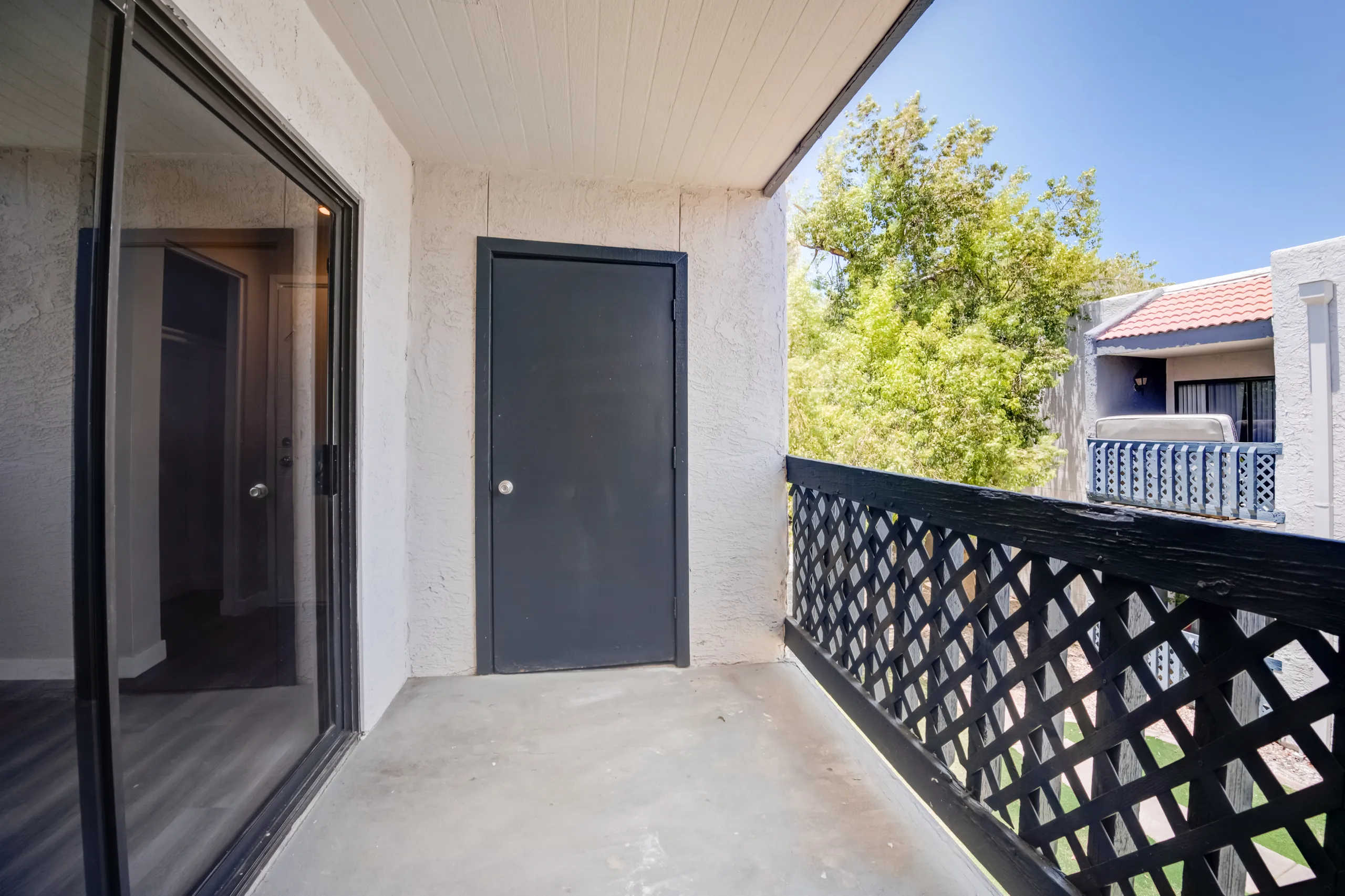 Private balcony with lattice railing and storage closet