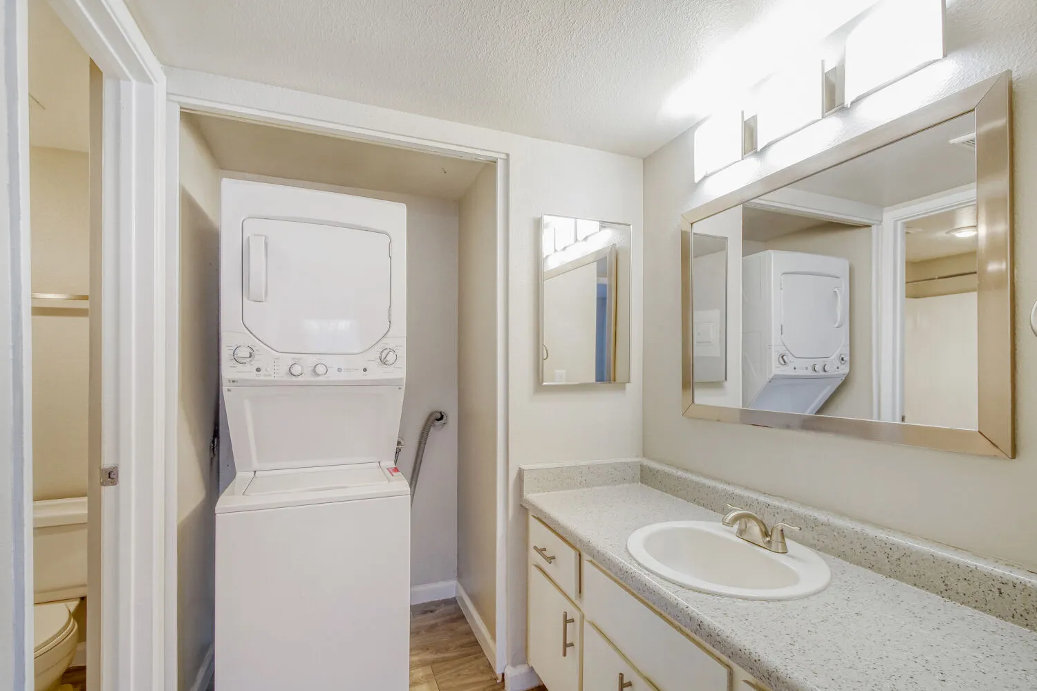 Primary bathroom vanity with in-unit stacked washer and dryer