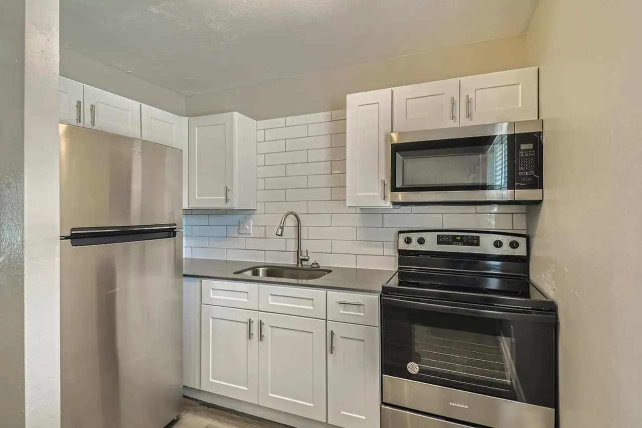 Kitchen, white shaker cabinetry, subway tile backsplash, stainless appliances, black electric range
