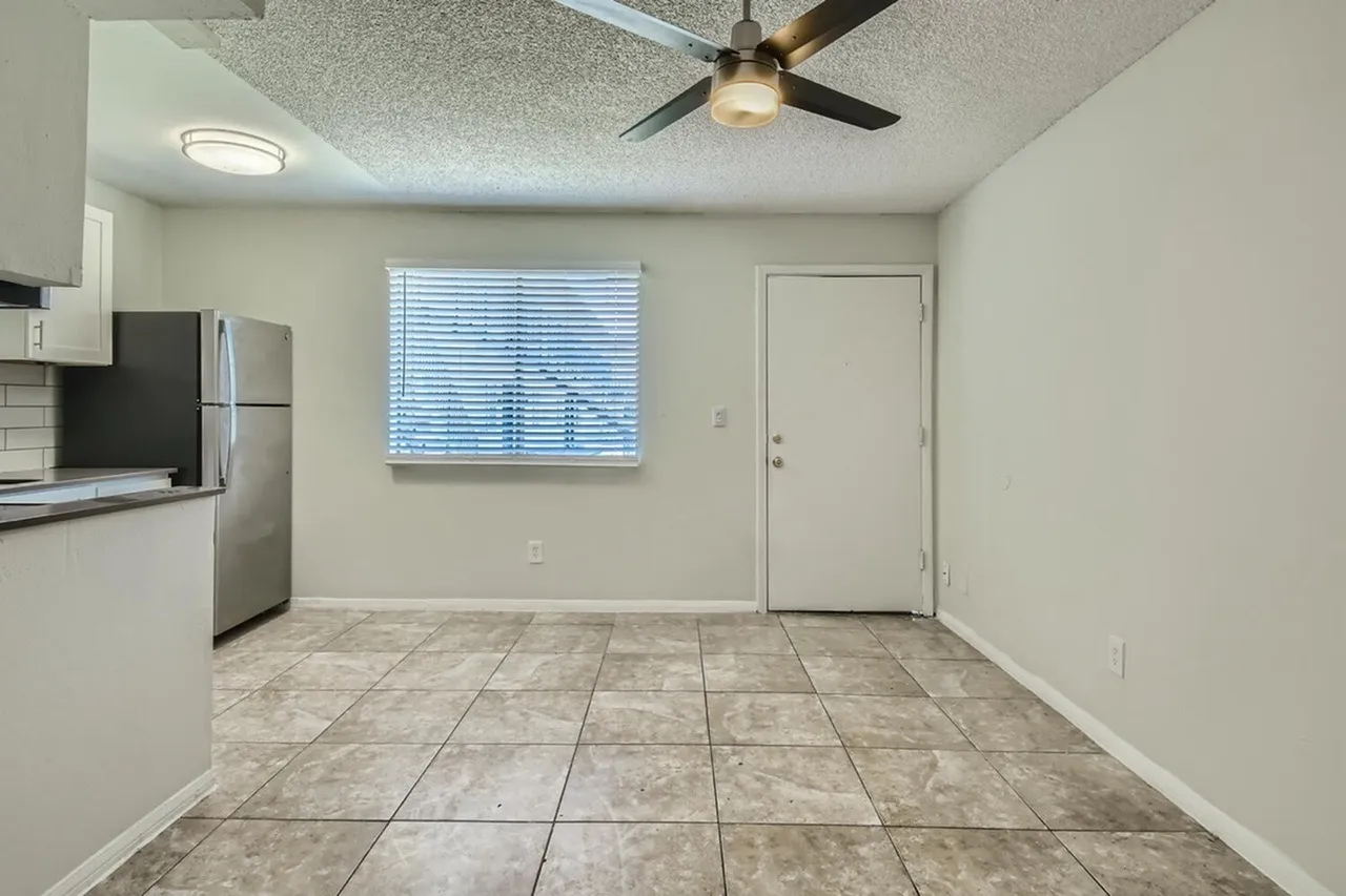 Kitchen and dining area, stainless steel appliances, tile flooring, ceiling fan with light fixture