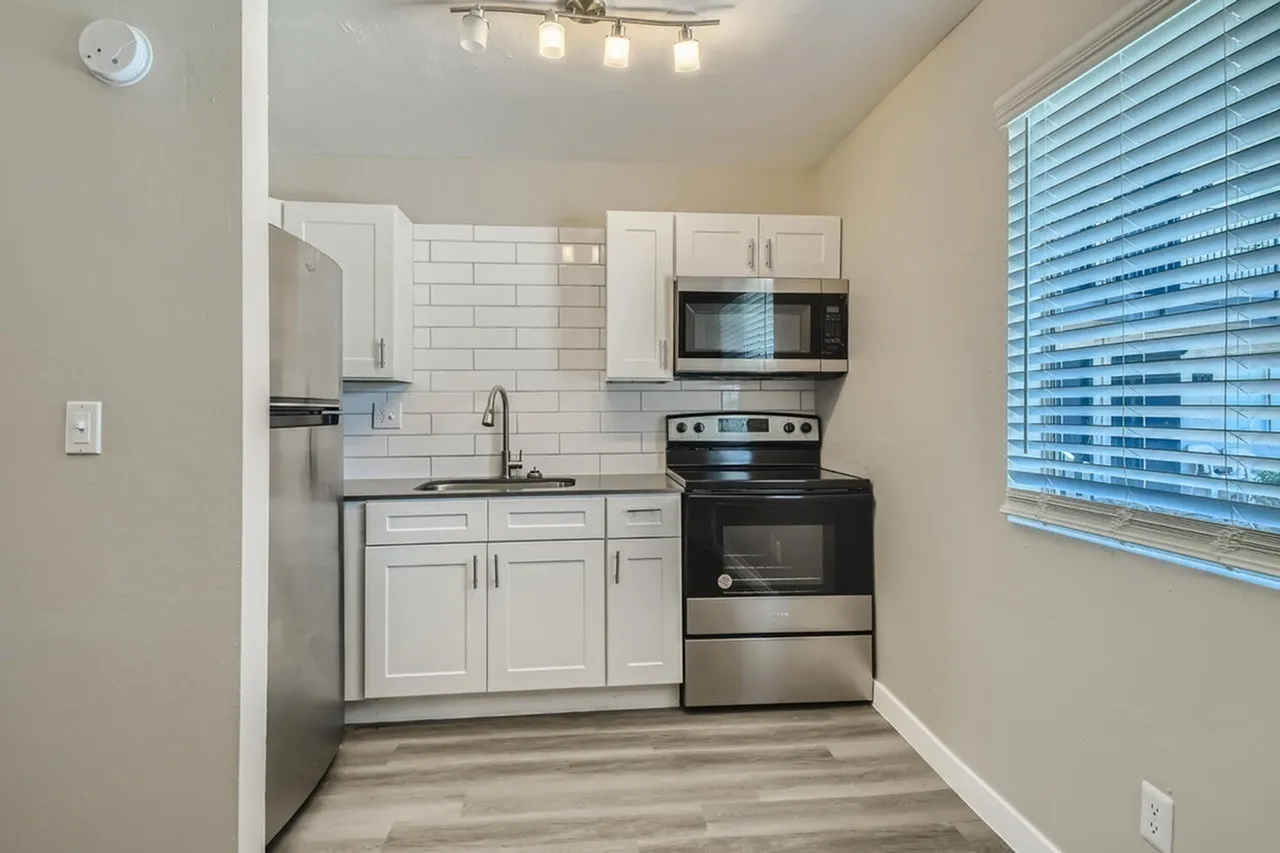 Kitchen, white shaker cabinetry, subway tile backsplash, stainless steel appliances, wood-style plank flooring