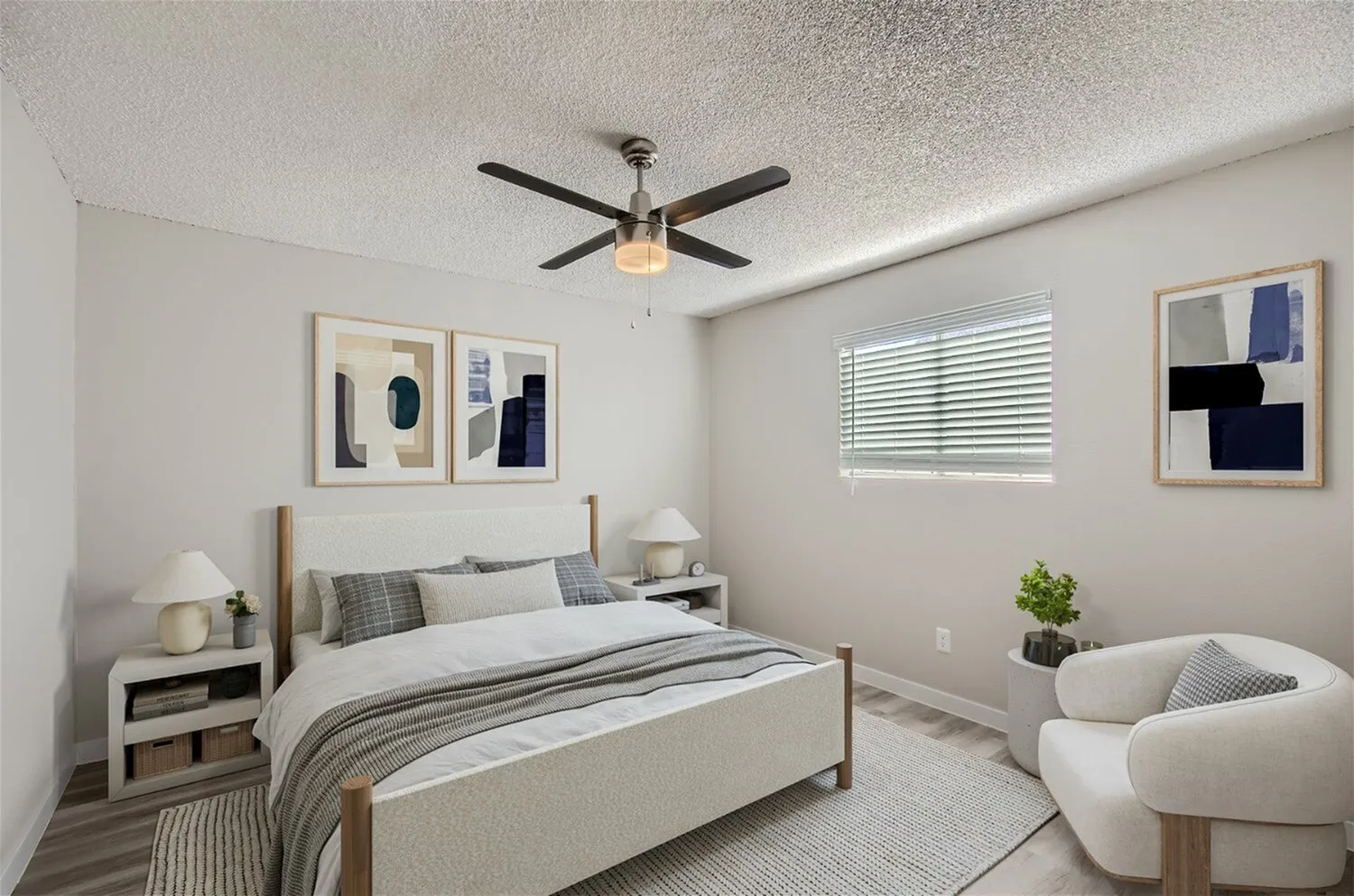 Primary bedroom, wood-style plank flooring, ceiling fan, upholstered bed frame, framed artwork