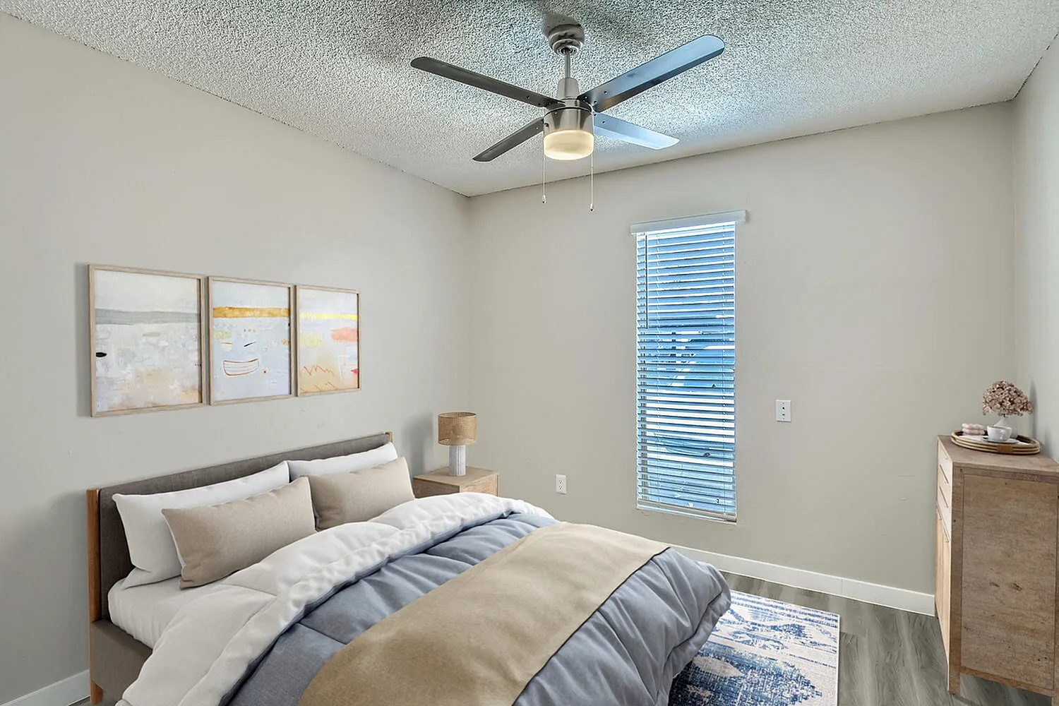 Primary bedroom, ceiling fan with light, blue striped bedding, wood nightstand, miniblinds window