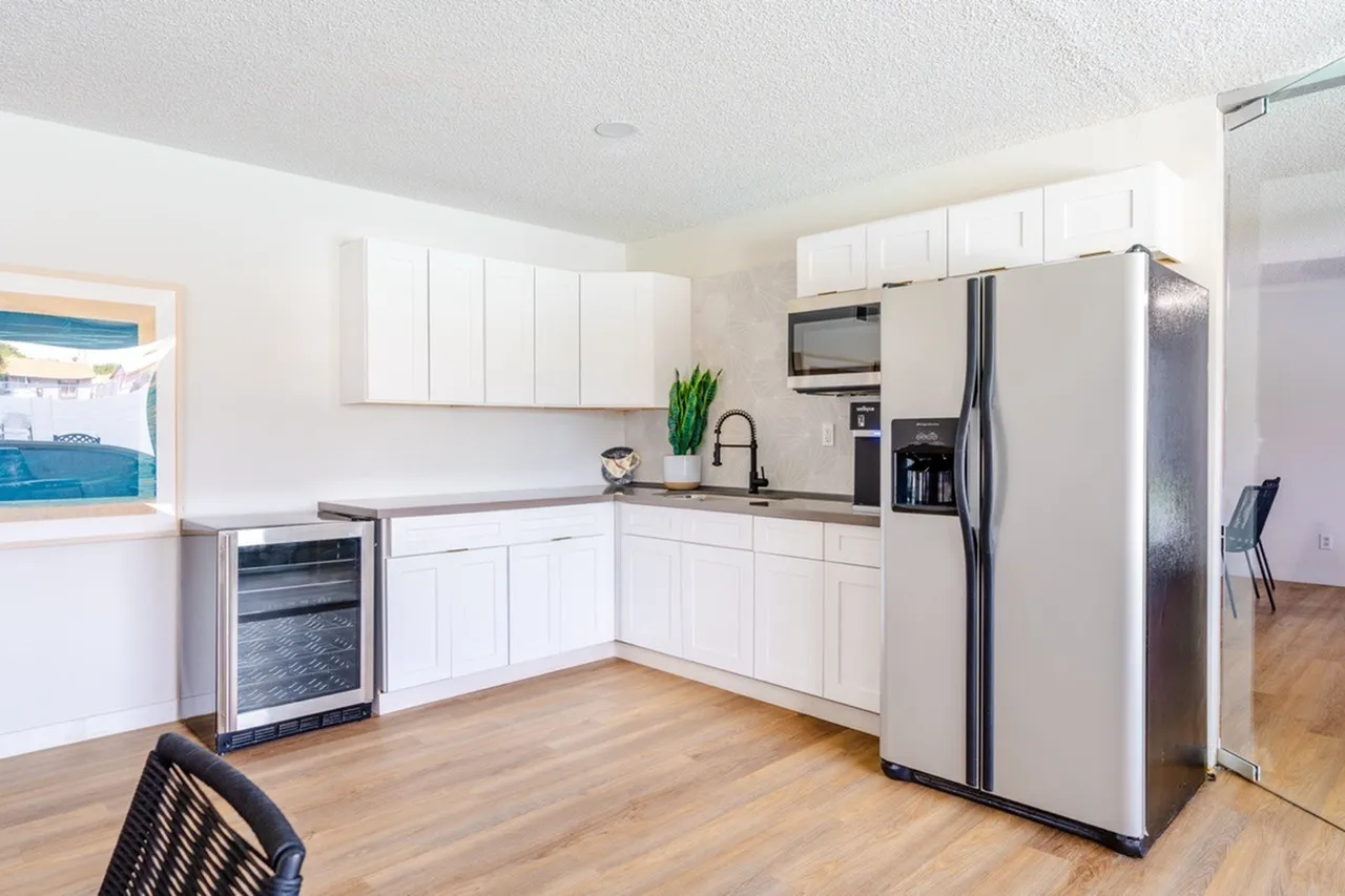 Kitchen, white shaker cabinetry, stainless steel appliances, wood-style plank flooring, granite countertops
