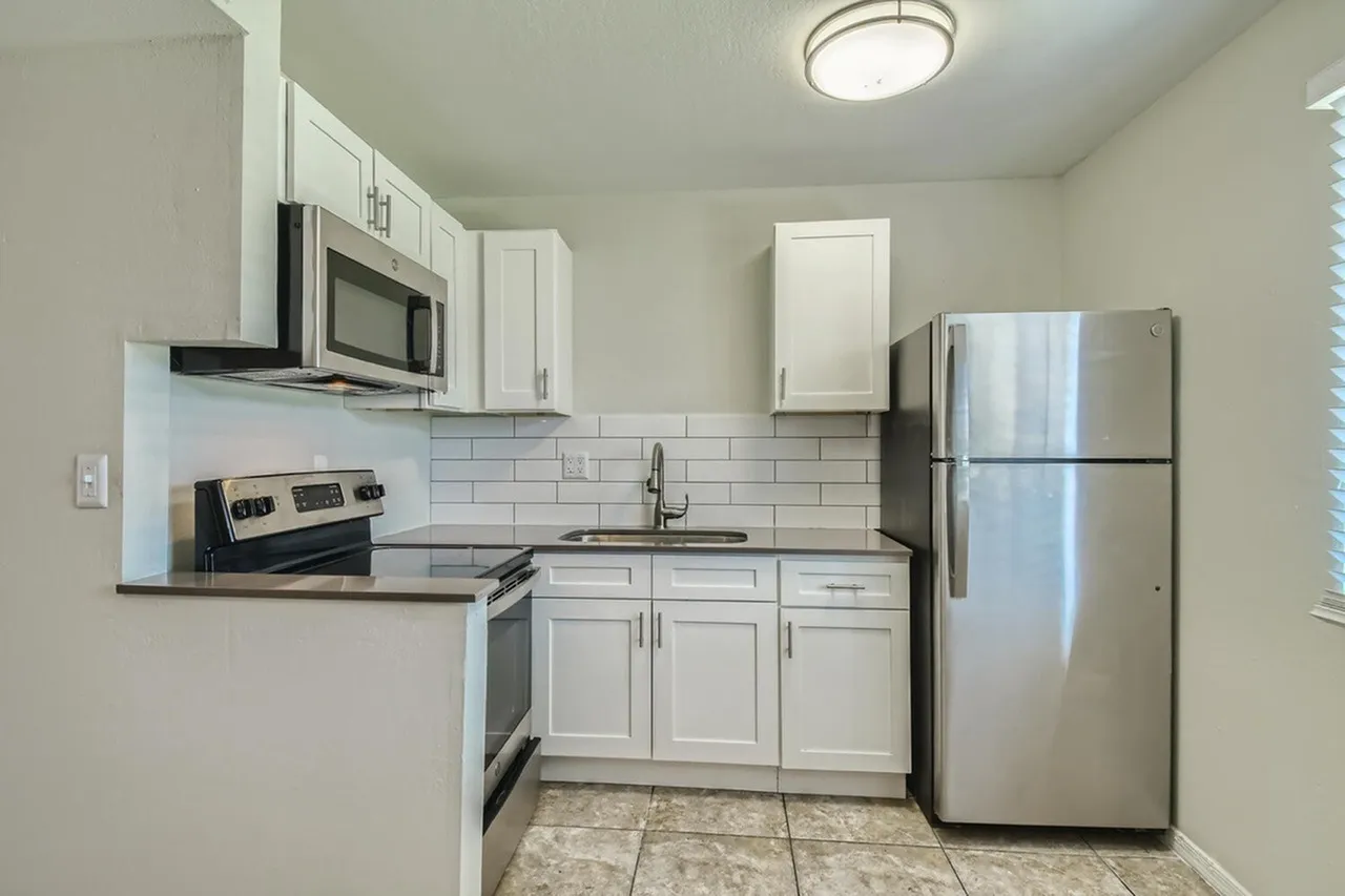 Kitchen, white shaker cabinetry, subway tile backsplash, stainless steel appliances, tile flooring