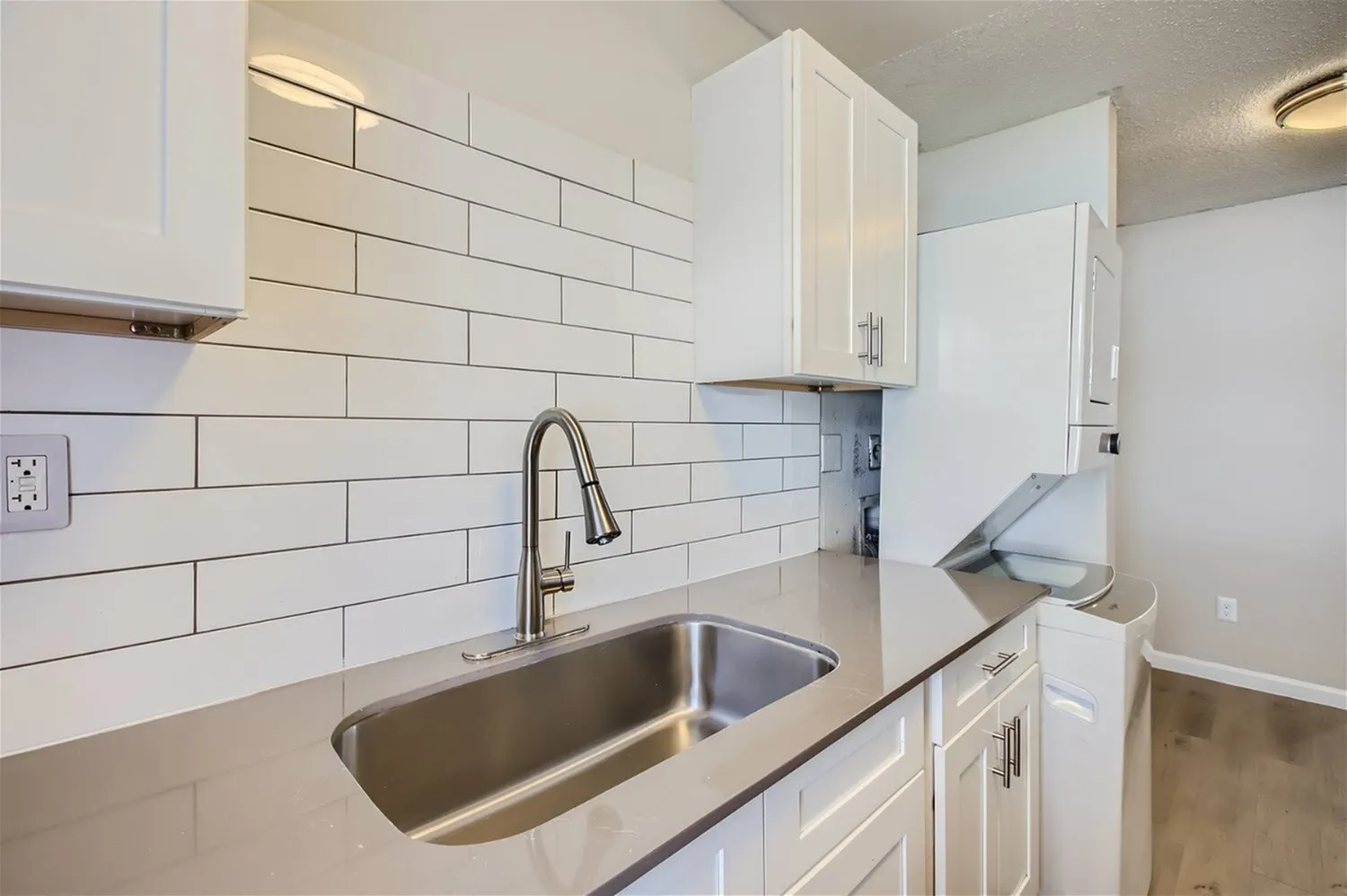 Kitchen, white shaker cabinetry, subway tile backsplash, stainless steel sink, granite countertops