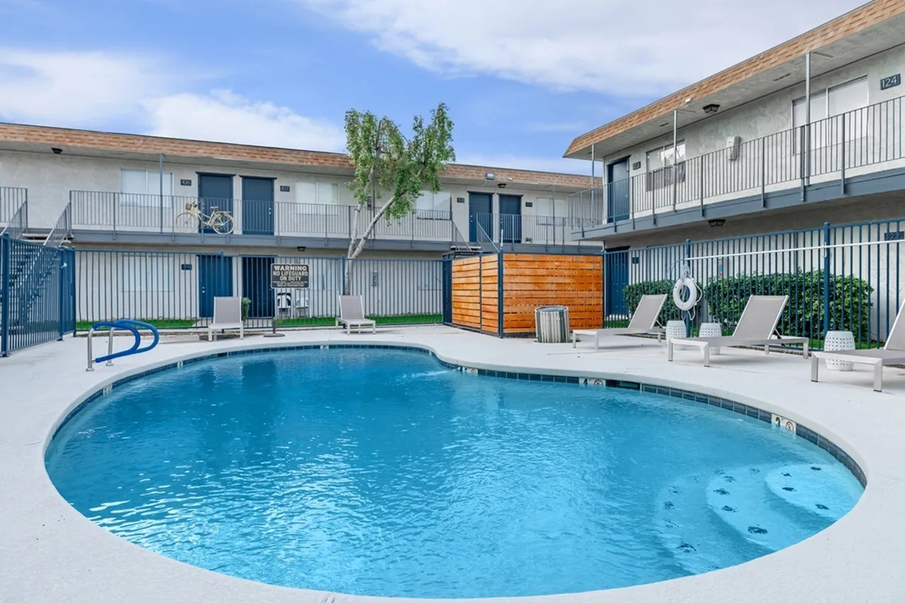 Resort pool, lounge chairs, wooden privacy screen, landscaped patio