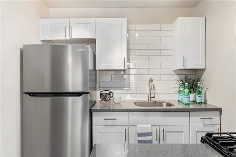 Kitchen, white shaker cabinetry, stainless steel appliances, gray quartz countertops, subway tile backsplash