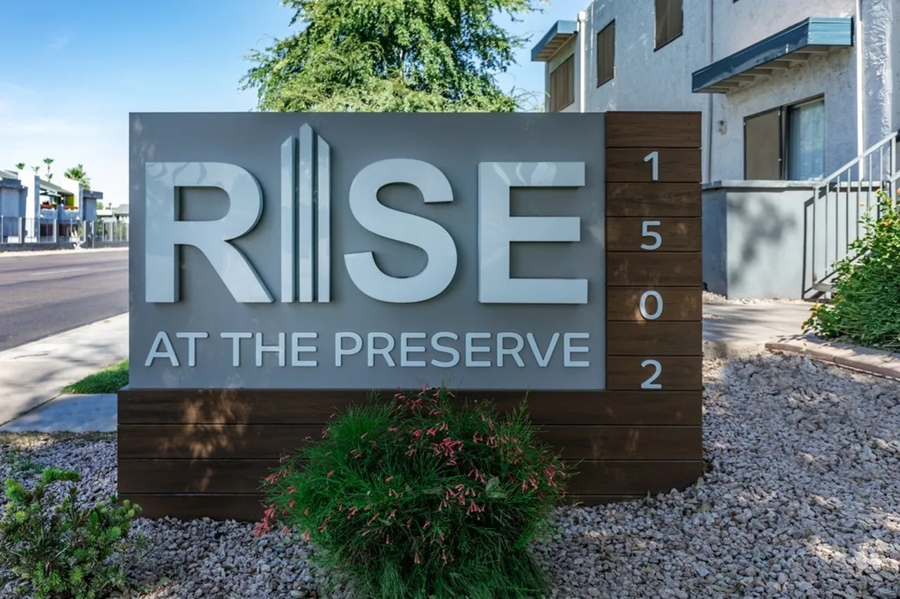 Property exterior signage, dimensional lettering, wood and metal materials, landscaping, modern building entrance