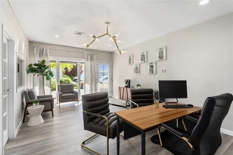 Home office, wood-style plank flooring, black desk chair, wood desktop, desktop computer monitor