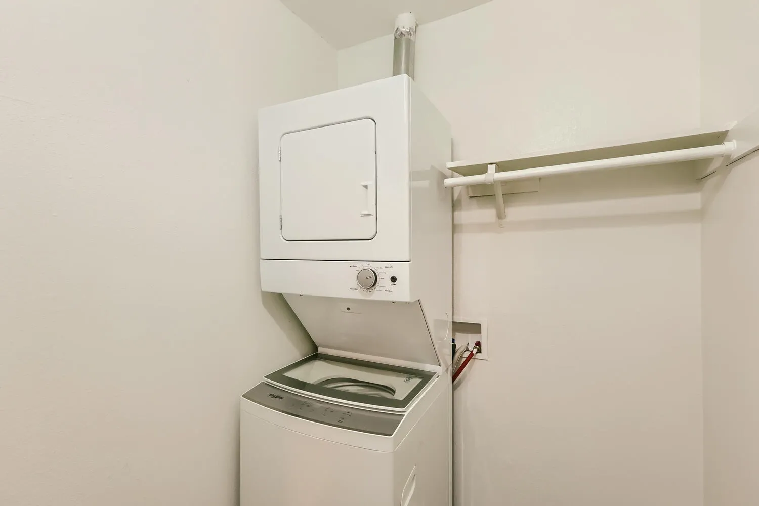 Laundry closet, white stackable washer dryer unit, wall-mounted drying rack, white walls