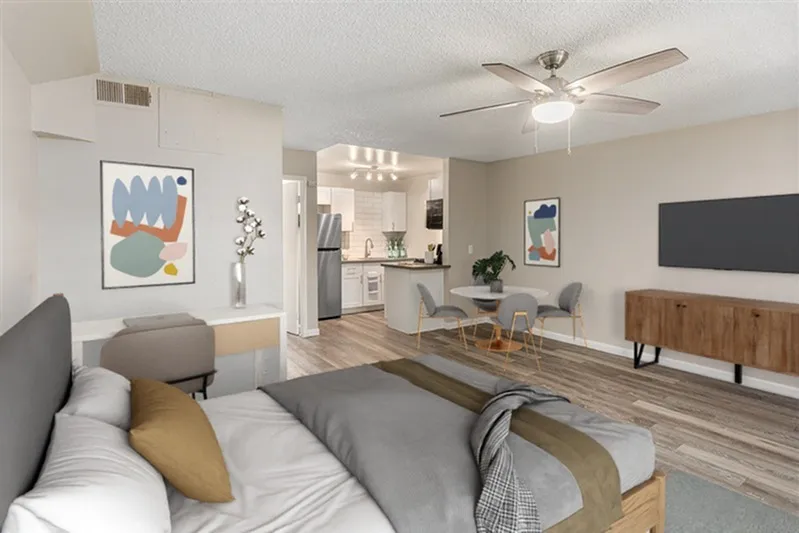 Studio layout with wood-style plank flooring, ceiling fan with light, stainless appliances