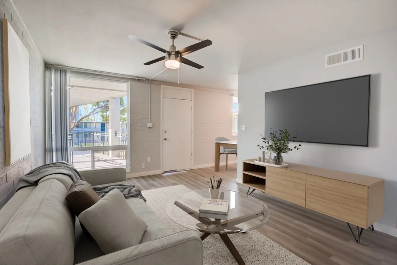 Living room, wood-style plank flooring, ceiling fan, wall-mounted TV, glass sliding door