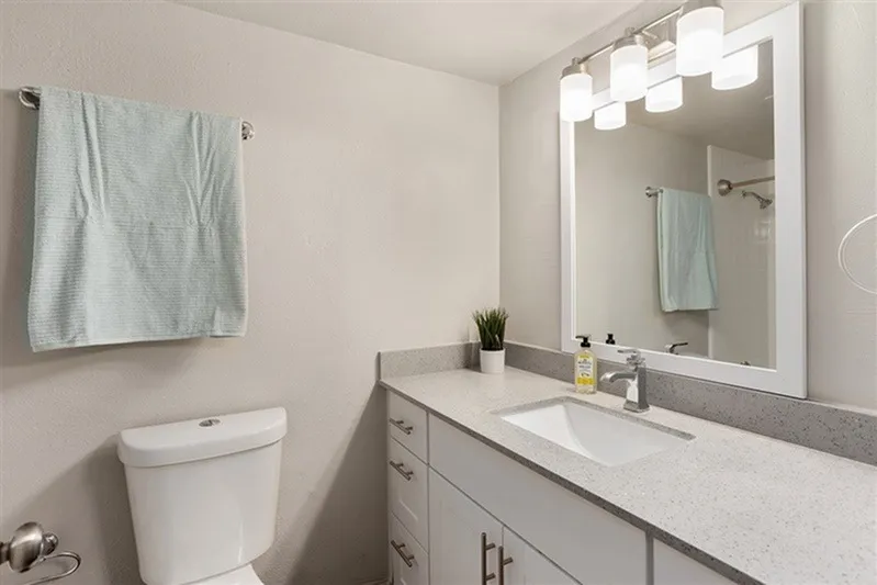 Bathroom, gray cabinetry, quartz countertops, illuminated mirror, vessel sink