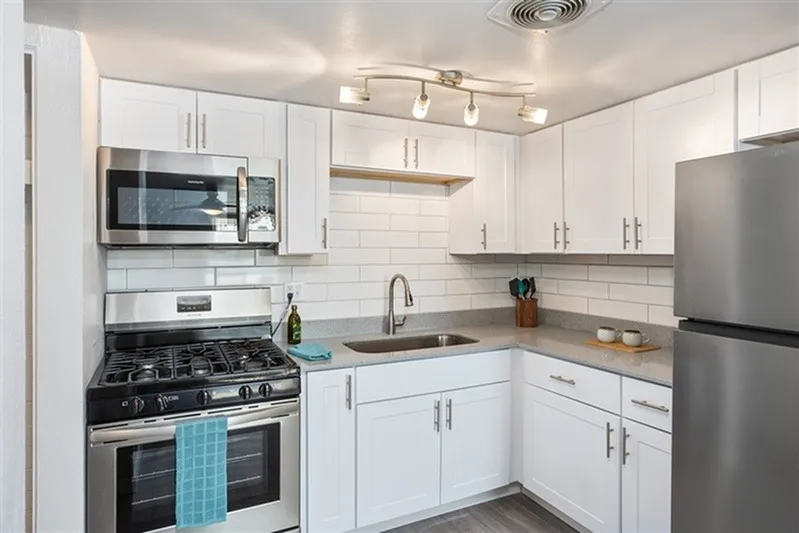 Kitchen, white shaker cabinetry, subway tile backsplash, stainless steel appliances, granite countertops
