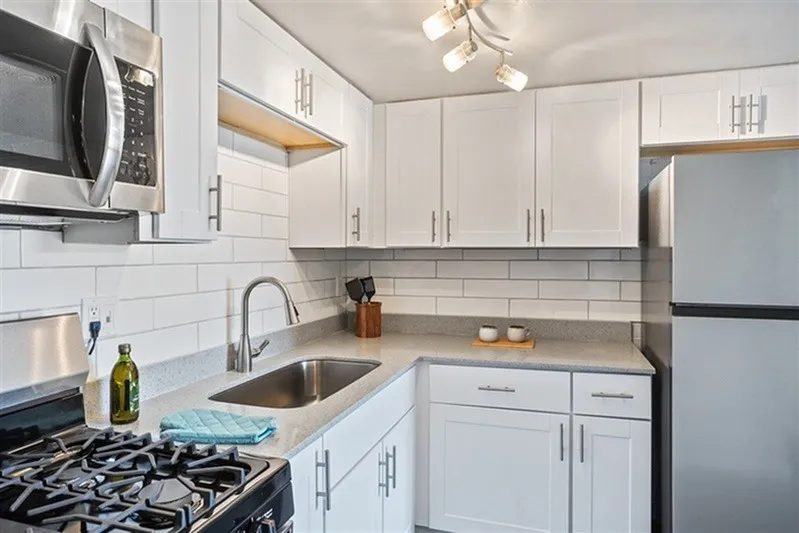 Kitchen, white shaker cabinetry, gray quartz countertops, stainless steel appliances, subway tile backsplash