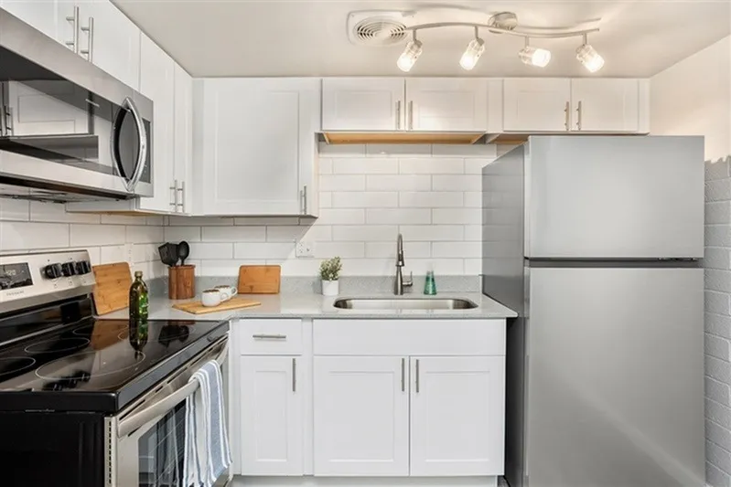 Kitchen, white shaker cabinetry, white subway tile backsplash, stainless steel appliances, quartz countertops