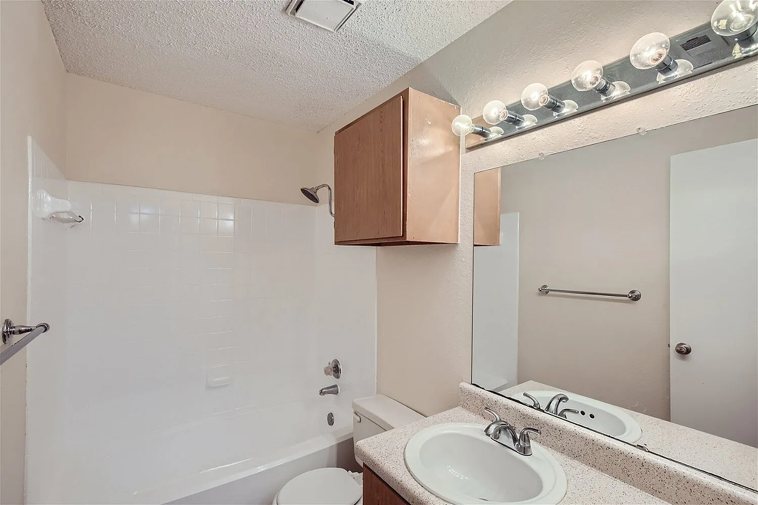 Bathroom, quartz countertops, round vessel sink, wood vanity cabinet, large mirror with sconces