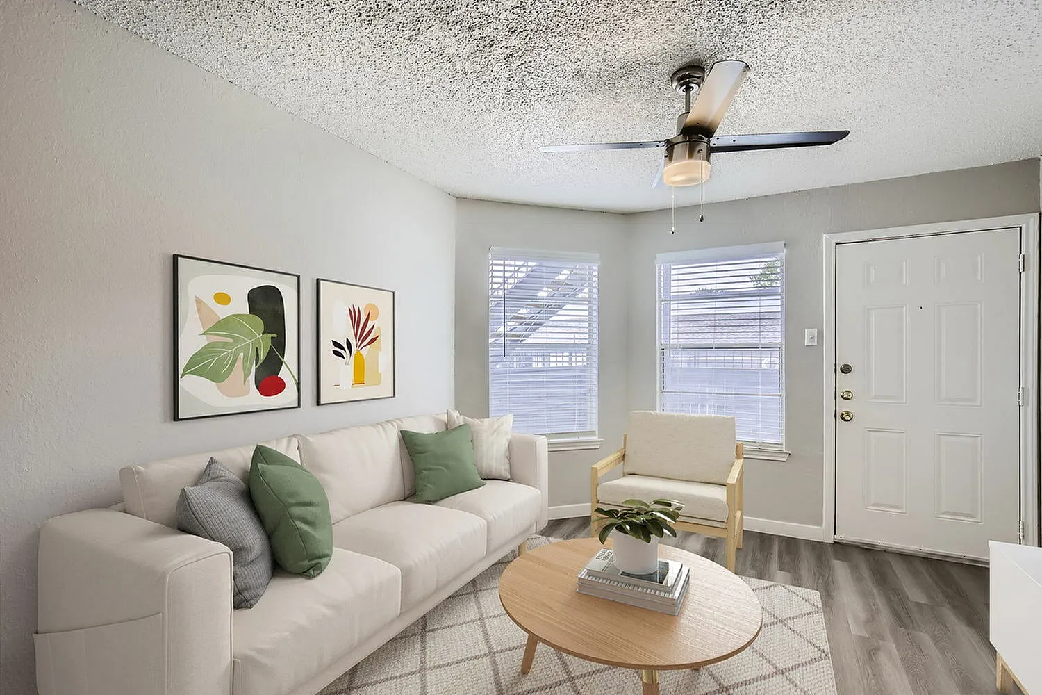 Living room, cream sofa, wood-style plank flooring, ceiling fan, glass entry doors