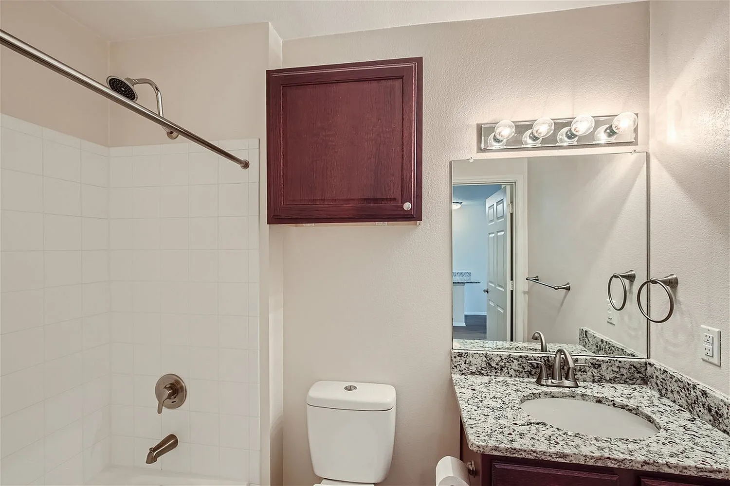 Bathroom, granite countertop, dual mirror, burgundy cabinet, toilet